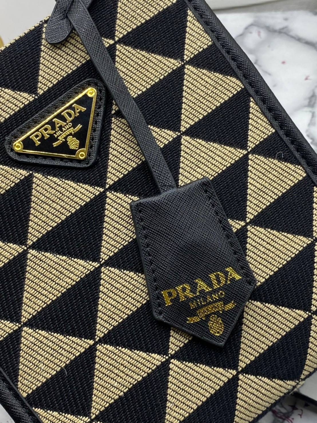 PRADA Symbole jacquard fabric micro bag / Prada triangle ไซส์มินิ แบบใหม่ล่าสุดจากแบรนด์ดัง จัดให้แบบเลิศๆ กับกระเป๋าทรงโท้ท สวยเอกลักษณ์ ภายในโล่งกว้างมาก ใส่ของแบบแน่นๆ จุๆไปได้เลย หมดห่วง!! และยังมีสายครอสบอดี้มาให้ จะสะพายชิคๆคูลๆ จะถือแบบปังๆ ก็เอาอย