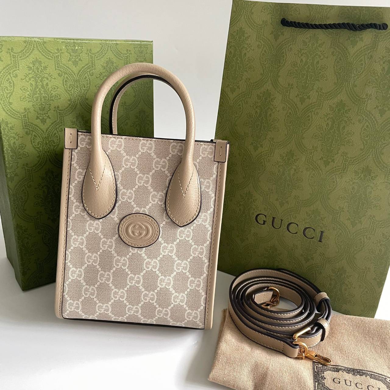หนังแท้ GUCCI Mini tote bag with Interlocking G พร้อมส่งที่ไทย Beige and white GG Supreme canvas เกรดออริจินอล ภาพสินค้าถ่ายจากงานขายจริง ใช้งานต่างประเทศได้ The mini tote bag is complete with an oatmeal leather trim and an Interlocking G tag.