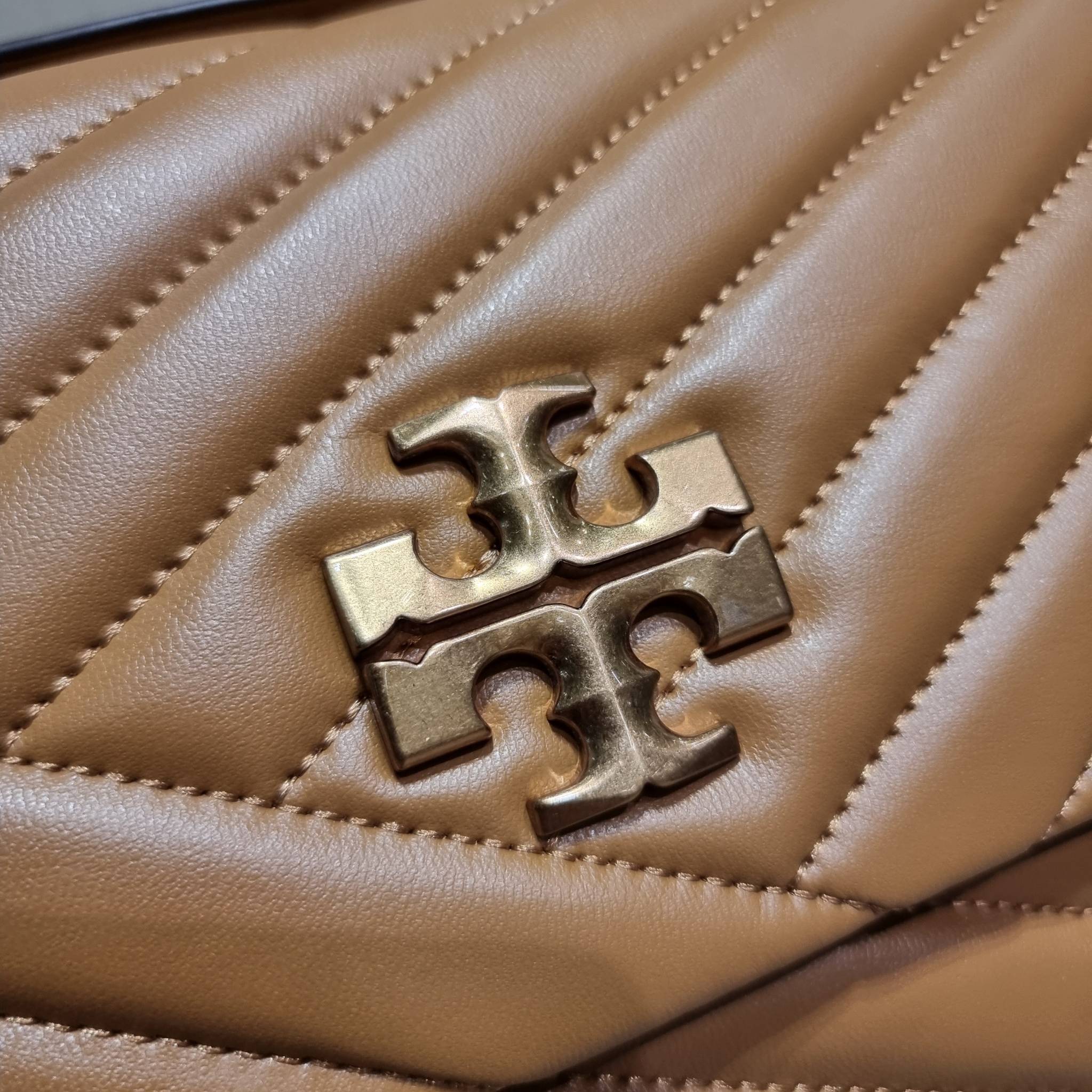 TORY BURCH KIRA CHEVRON CONVERTIBLE SHOULDER BAG กระเป๋าสะพายรุ่นยอดฮิต ไซส์ใหญ่จัดเต็มให้เน้นๆ ใช้ยังไงก็ดูหรู ดีไซน์เฉพาะตัว วัสดุหนังแกะ สัมผัสนิ่ม เปิด-ปิดด้วยกระดุมแม่เหล็ก ภายในเป็นช่องโล่ง แบ่งสัดส่วนไว้ดีมากๆ ใส่กระเป๋าสตางค์ มือถือ เครื่องสำอางค์