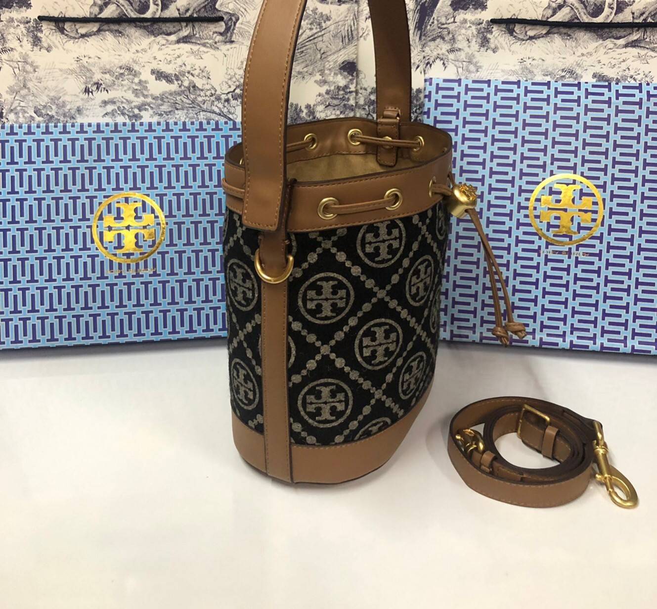 Medium : Tory Burch T Monogram Chenille Bucket Bag เปิดตัวอีกหนึ่งรุ่นกับกระเป๋าลาย T MONOGRAM รุ่นใหม่ล่าสุดจาก TORY BURCH พลาดไม่ได้กับโลโก้สุดคลาสสิก ลวดลาย T Monogram คือวัสดุ chenille หรือที่เรียกว่า ด้านไหมกำมะหยี่ มารังสรรค์ลงบนกระเป๋าBucketใบนี้ เ