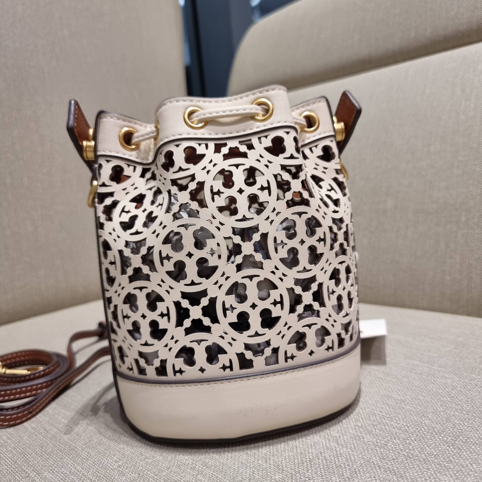 TORY BURCH T MONOGRAM LASER-CUT MINI BUCKET BAG ใจบางที่สุดกับคอลเลคชั่นนี้ กับกระเป๋าสะพายทรงบัคเก็ต ไซส์มินิ รุ่นชูโรงสุดฮิต ที่เพิ่มดีเทลความแพงด้วยการฉลุลวดลายโมโนแกรมรอบใบ ถักทอเป็นเส้นลายสานที่สวยงามมาก งานฝีมือจริงๆ วัสดุหนัง cowhide รูดเปิด-ปิดด้ว