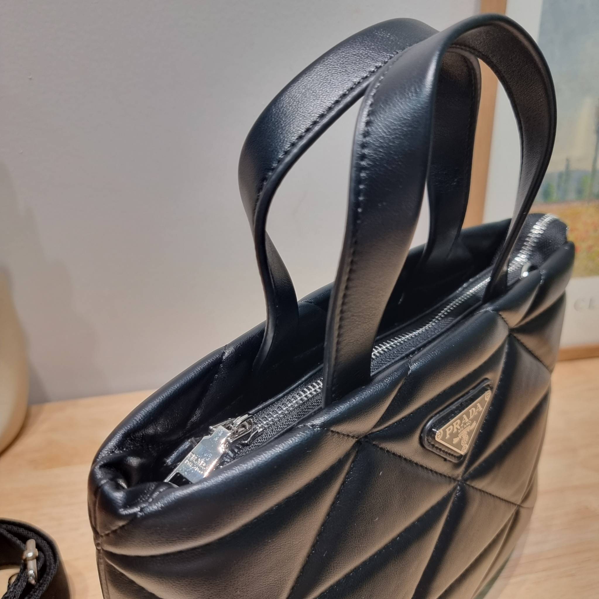 PRADA LEATHER PADDED BAG ใหม่ล่าสุด กับคอลเลคชั่นที่ทำออกมาตอบโจทย์ได้ทุกไลฟ์สไตล์ และเป็นยูนิเซ็กส์ กับกระเป๋าทรงโท้ท ขนาดกำลังดี