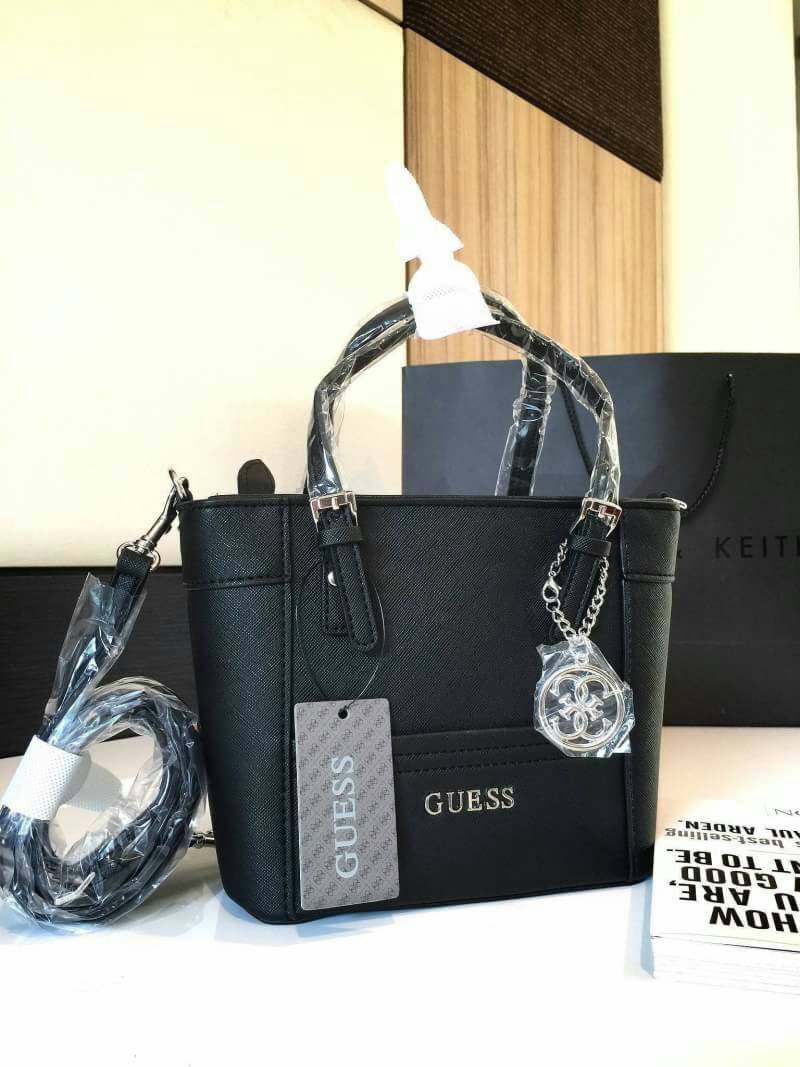 GUESS SAFFIANO MINI CROSS BODY BAG Best aellwr กระเป๋าถือหรือสะพายรุ่นยอดนิยมจาก GUESS หนัง Saffiano สวยอยู่ทรงสไตล์ PRADA ขนาดกำลังดี เบา ด้านหน้าประดับ logo brand มาพร้อมพวงกุญแจแบรนด์ห้อยที่หูกระเป๋า ถอดเเยกใช้ได้ เปิดปิดด้วยซิปสะดวกใช้ ภายในมี โลโก้ ช
