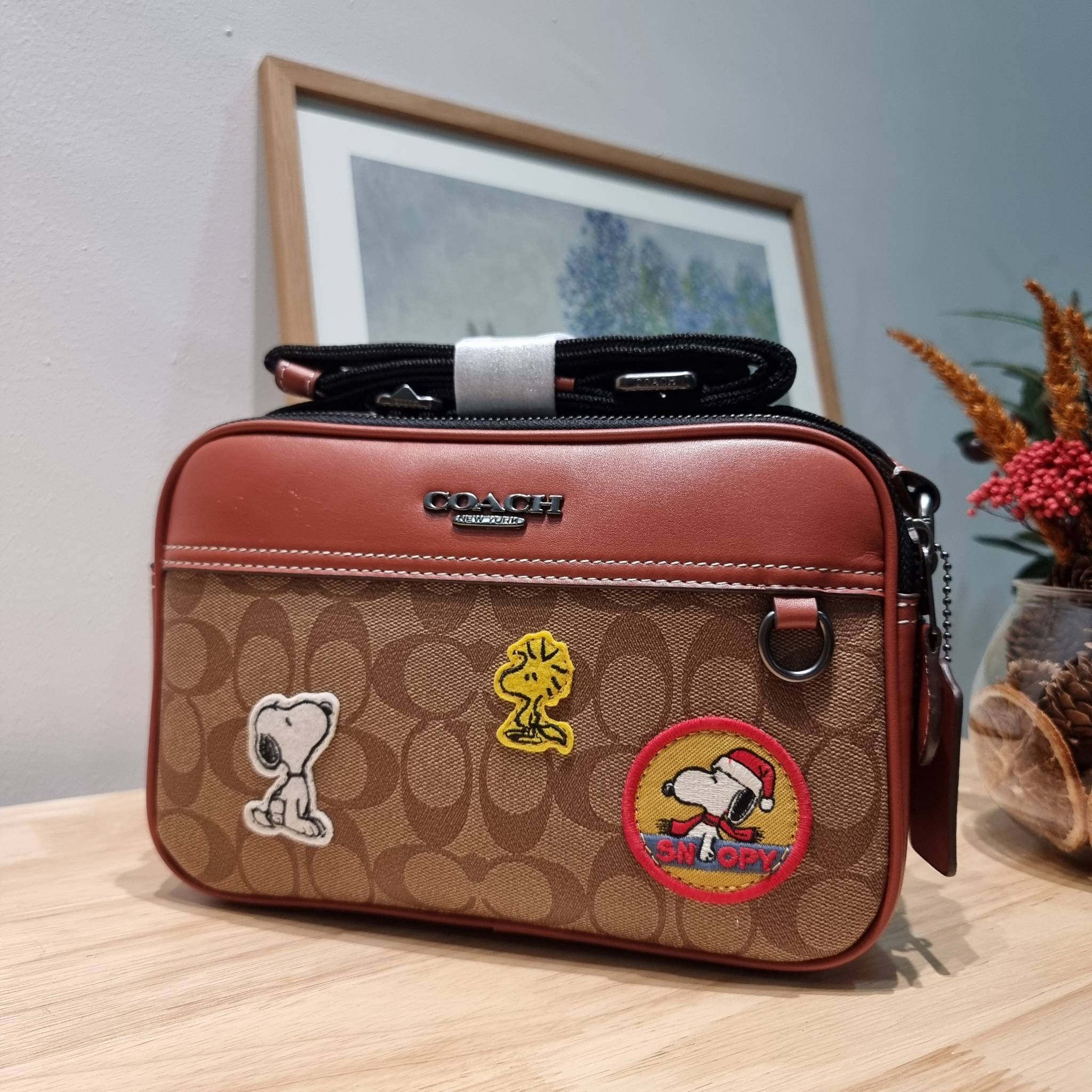 Coach X Peanuts Graham Crossbody In Signature Canvas With Patches CE746 กระเป๋าครอสบอดี้ทรงยอดฮิต กับคอลเลคชั่นใหม่ เฉลิมฉลองเทศกาลคริสต์มาส รุ่นนี้สามารถใช้ยูนิเซ็กส์ สาวๆหนุ่มๆได้หมด น่ารักน่าใช้เกิน!! รูปทรงดีไซน์คลาสสิค สีสันโดดเด่นสดใส ใช้งานสะดวก วั