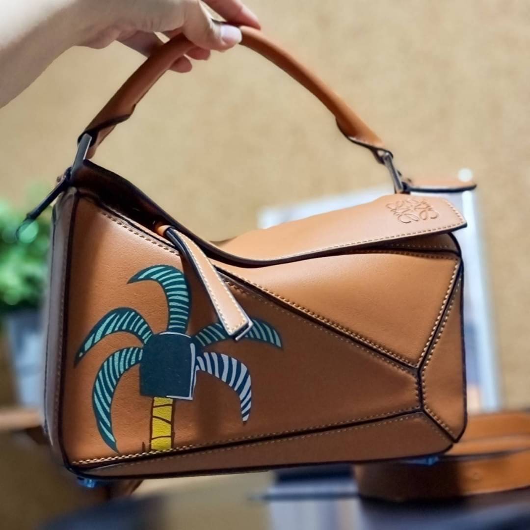 VIP 】LOEWE LA PALME PUZZLE BAG IN CLASSIC CALFSKIN คอลเลคชั่นใหม่!! กระเป๋าสะพายข้างทรงกล่อง สไตล์พัซเซิล ให้ฟีลลิ่งเหมือนตัวต่อ ดูดีได้ทุกที่แค่มีใบนี้ รอบนี้ดีไซน์พริ้นท์ลายต้นปาล์มเก๋ๆ ซัมเมอร์ยังต้องมา วัสดุหนังวัวฟอกสี เปิดใช้งานด้วยซิป ที่ภายในโล่งพ