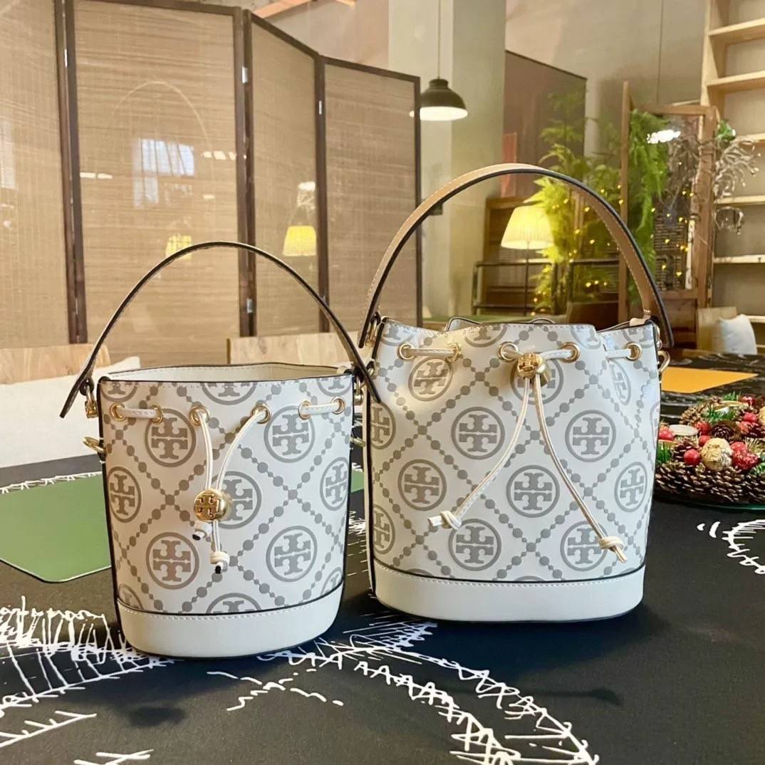 Tory Burch T Monogram Embossed Mini Bucket Bag กระเป๋าทรงถังขนาดเล็ก ประดับด้วยลวดลายอันเป็นสัญลักษณ์ของแบรนด์ ถูกประดิษขึ้นด้วยความพิถีพิถันวัสดุหนังอย่างดี ด้านในบุด้วยหนังไมโครซูแอคเนื้อนุ่มทำความสะอาดง่าย อะไหล่ทองหรูหรา มาพร้อมสายยาว ปรับสายได้ ถอดสา