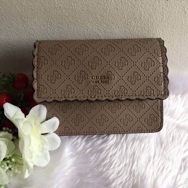 Guess Rayna Logo-Embossed Mini Crossbody กระเป๋าสะพายข้างทรง ครอสบอดี้ วัสดุหนัง pu ปั้มลาย Signature รอบใบรวมถึงสายยาว สวยตั้งอยู่ทรง ด้านหน้ามีโลโก้แบรนด์ เปิดปิดด้วยฝาปิดกระดุมแม่เหล็กซับในลายแบรนด์ มีช่องใส่บัตร ใส่มือถือ ของใช้จุกจิกได้เยอะ น้ำหนักเบ