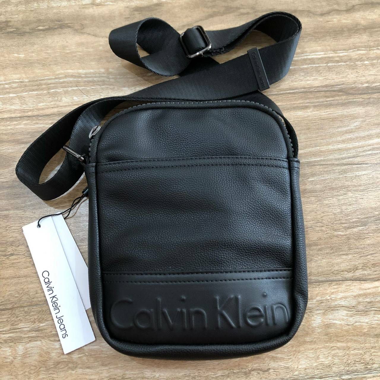 CALVIN KLEIN JEANS CROSSBODY BAG กระเป๋าสะพายจาก Calvin Klein Jeans วัสดุหนังpuคุณภาพดีเนื้อนิ่ม น้ำหนักเบา กันน้ำ ด้านหน้ามีปั้มโลโก้ เปิดปิดด้วยซิปสะดวกใช้ หัวซิปแบรนด์ ด้านหน้ามีช่องโล่งไว้ใส่ของหยิบใช่สะดวก ภายในมีโลโก้เเละช่องโล่ง ใส่กระเป๋าสตางค์ใบย