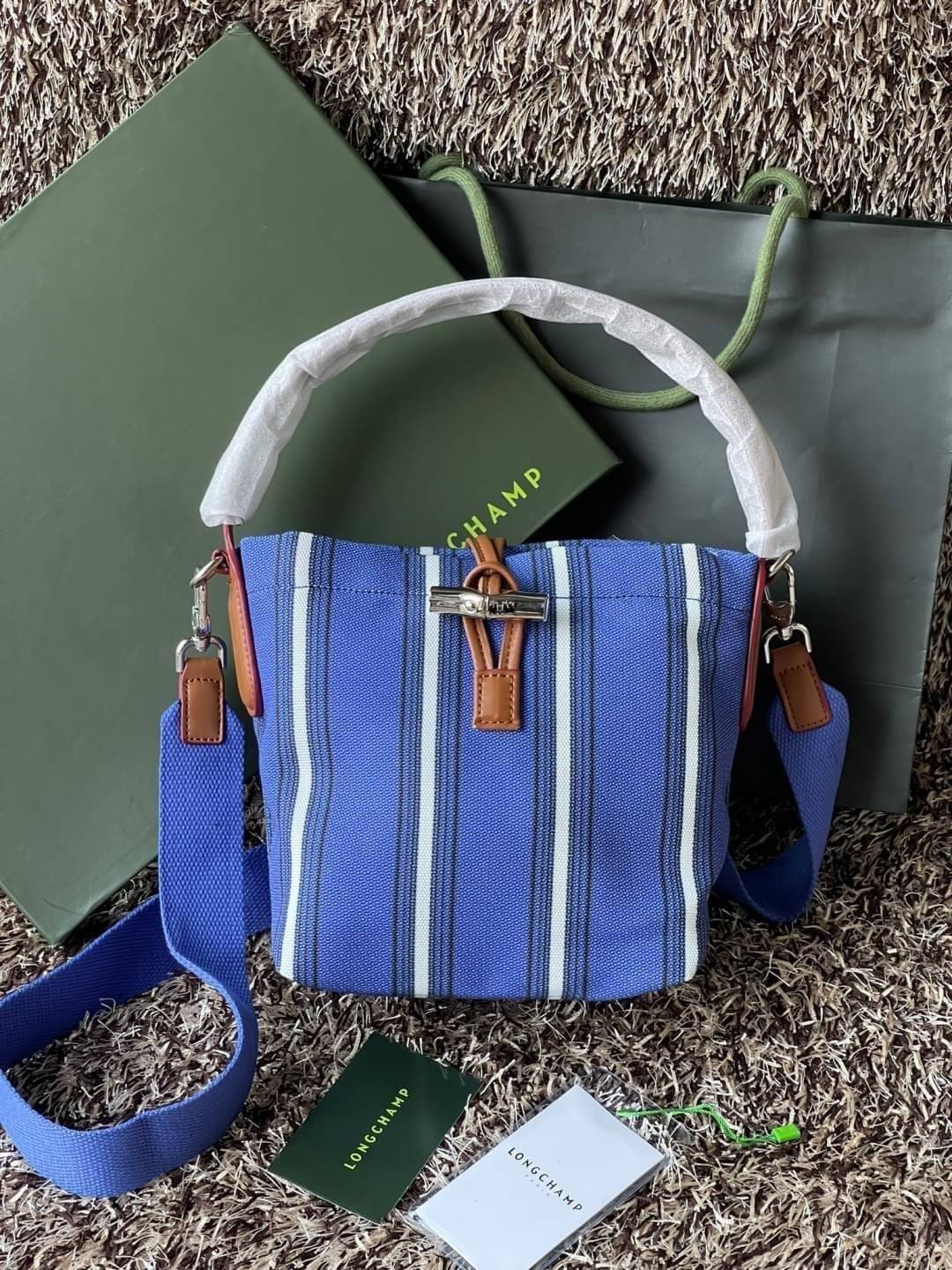 LONGCHAMP ROSEAU ESSENTIAL RAYÉ Bucket bag S - Blue สำหรับใครที่ต้องการกระเป๋าแบบใช้งานได้ในหลาย ๆ โอกาส สีสันกระเป๋าสามารถแมทช์ได้ง่ายกับเสื้อผ้า Longchamp รุ่นนี้สามารถตอบโจทย์ เป็นกระเป๋าที่ขนาดกำลังพอดี