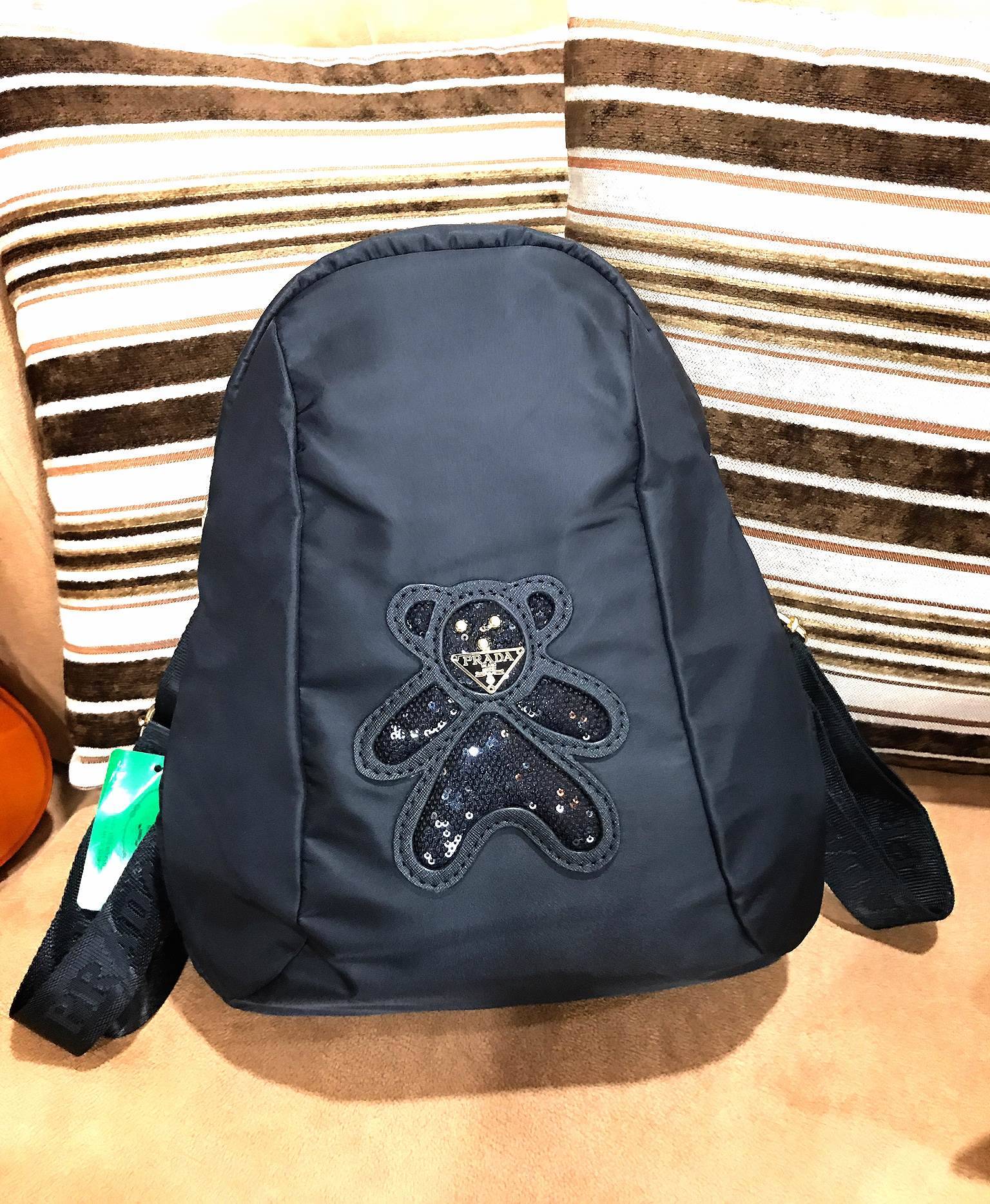 Don't Miss! PRADA NYLON BACKPACK กระเป๋าสะพายเป้ พรีเมี่ยมกิ้ฟจากเคาน์เตอร์ต่างประเทศรุ่น Limited edition ที่ฮ๊อตสุดๆ วัสดุเป็น Nylon เนื้อหนาคุณภาพดีตามแบบฉบับของแบรนด์ ขนาดกำลังดี น้ำหนักเบา ด้านหน้าเป็นลายหมีปั๊กกลิ้ตเตอร์โลโก้แบรนด์อะไหล่ทองหรู ภ