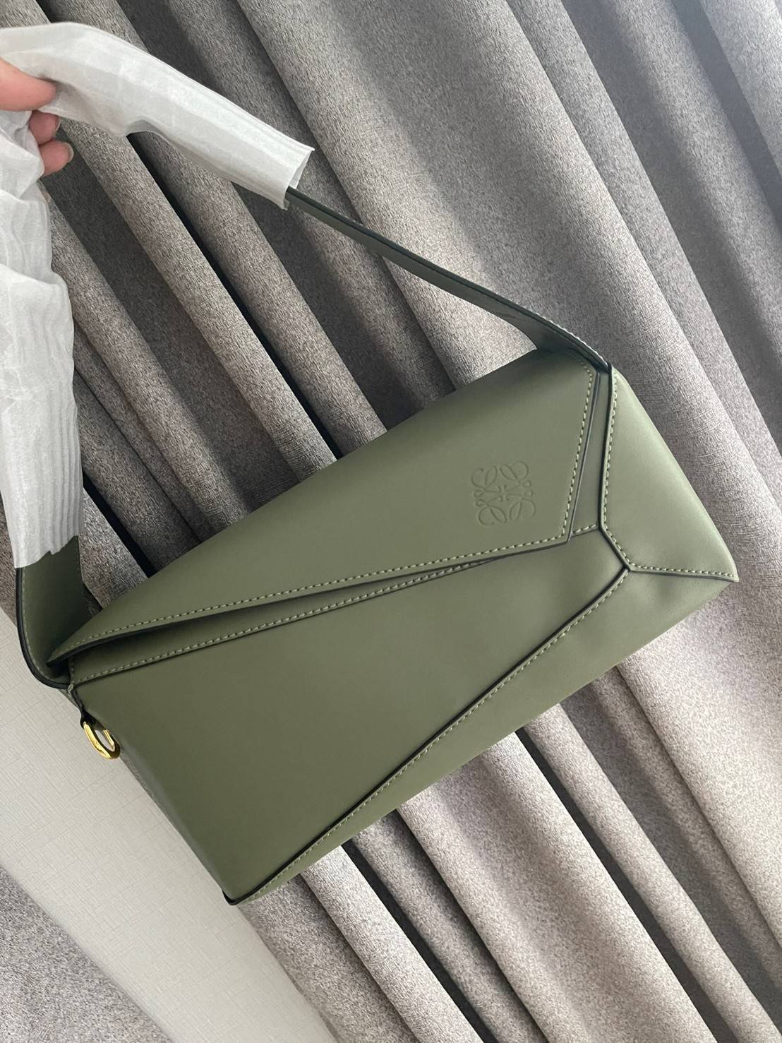 Loewe Puzzle Hobo bag กระเป๋ารุ่น Puzzle มีความพิเศษในหลายด้าน ไม่ว่าจะเป็นรูปทรงที่แปลกใหม่ มินิมอลด้วยโลโก้อนาแกรมแบบประทับ ดูหรู เป็นกระเป๋า Unisex ที่ไม่ว่าคุณจะเป็นผู้หญิงหรือผู้ชายก็ใช้งานได้ ลายกระเป๋าได้มาจากการนำหนังมาเย็บต่อกันทั้งหมด ถึงแม้ว่าข