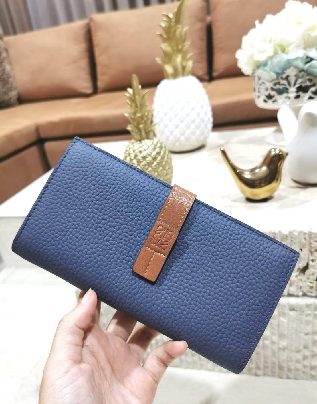 LOEWE LONG WALLET BAG วัสดุหนังแท้เทคเจอร์สวยอยู่ทรงปั้มโลโก้แบรนด์ด้านหน้าเปิดปิดด้วยกระดุม ภายในมีช่องใส่ธนบัตรหลายช่อง ช่องหลักสามารถใส่มือถือได้ มีช่องซิปใส่เหรียญ ช่องใส่ธนบัตรใส่แบงก์พันได้ สวยน่าใช้ พร้อมส่งที่ไทยสุดคุ้มห้ามพลาด!