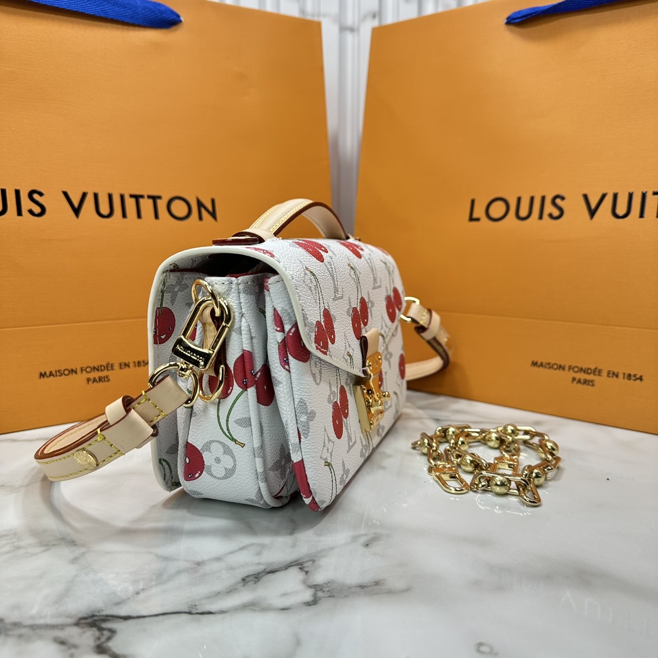 ORI หนังแท้ | LV x TM Pochette Métis East West Monogram cherry canvas กระเป๋าสะพาย ดีไซน์ใหม่โทนสีขาวในเฉดสีฤดูร้อนซึ่งตัดกับลวดลายเชอร์รี่สดใสที่ได้รับแรงบันดาลใจจากศิลปินชาวญี่ปุ่นได้อย่างสง่างาม