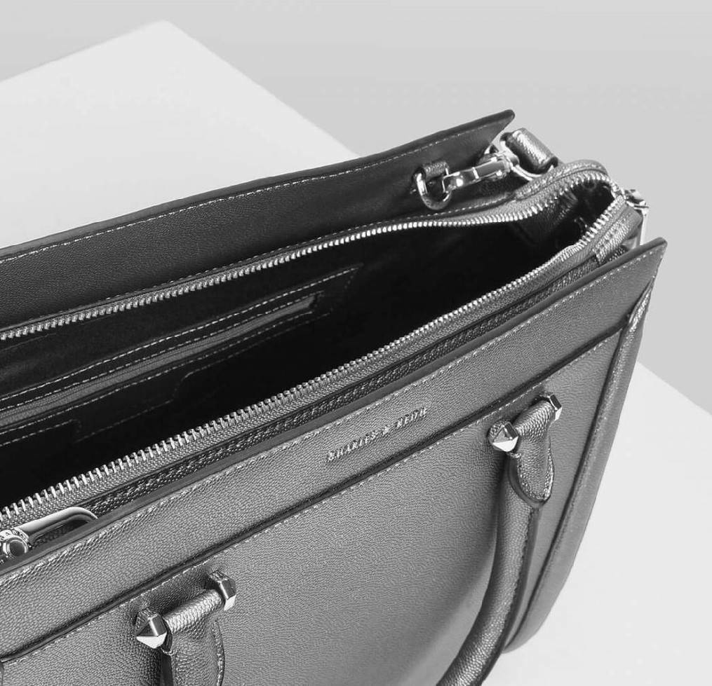 CHARLES & KEITH SAFFIANO TRAPEZE BAG กระเป๋าถือหรือสะพายรุ่นยอดนิยมดีไซน์สวยหรูวัสดุหนังคาเวียร์อยู่ทรง ด้านข้างเเต่งหนังช่องตัดดูมีดีเทล ด้านหน้ามีโลโก้ ด้านหลังมีช่องซิป เปิดปิดด้วยซิปหัวซิปแบรนด์ หูจับเเข็งแรง พับลงได้ พร้อมสายสะพายหนังปรับระดับได้ถอดไ