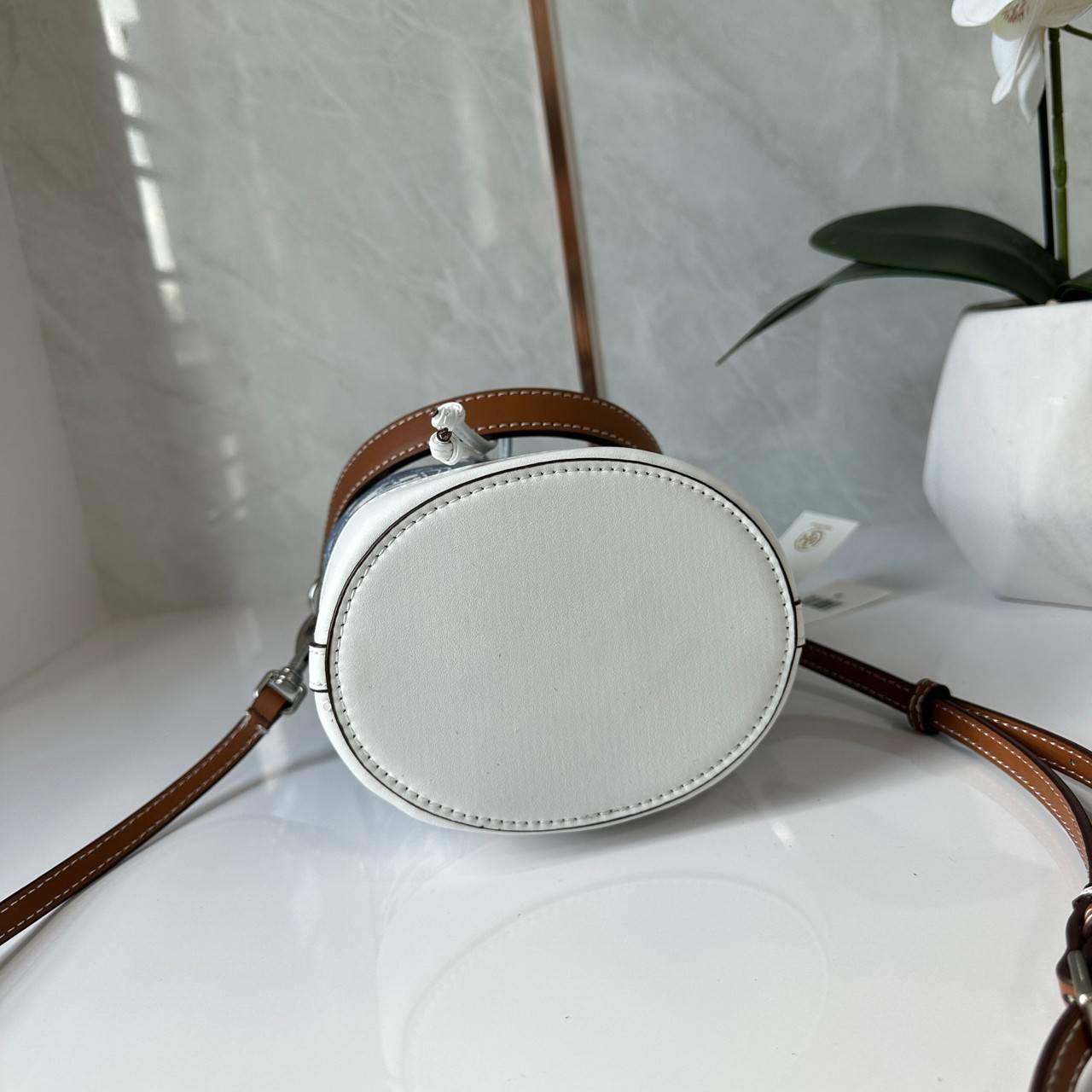 TORY BURCH Mini T Monogram Denim Bucket Bag คอลเลคชั่นใหม่ รูปแบบคลาสสิค พกพาความหรูหราไปได้ทุกที่ด้วยกระเป๋าทรง Bucket ขนาดกลางและปิดด้วยเชือกรูดพร้อมโลโก้แวววาว วัสดุผ้าเดนิมแจ็คการ์ด ตัดขอบหนังแท้ สวยหรู ทันสมัยสุดๆคะ