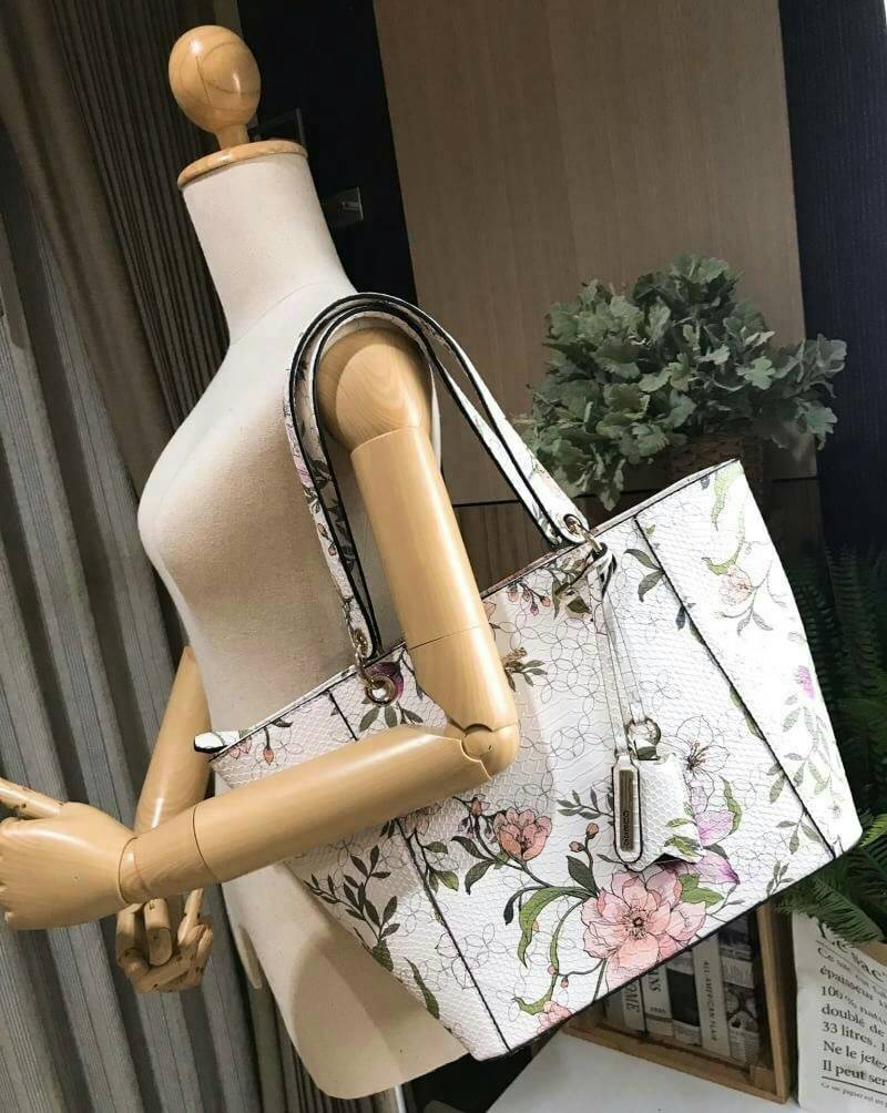 GUESS PRINTED KAMRYN FLOWERS SHOPPER BAG (SIZE L) กระเป๋าสะพายจาก GUESS FACTORY หนังสวยอยู่ทรงปริ้นลายดอกไม้คอลเลคชั่นล่าสุดใบใหญ่กำลังดี ใส่สัมภาระได้จุใจ น้ำหนักเบา ด้านหน้าประดับโลโก้แบรนด์อะไหล่เงินพร้อมพวงกุญแจแบรนด์ห้อยที่หูหิ้วถอดเเยกใช้ได้ หูหิ้วพ