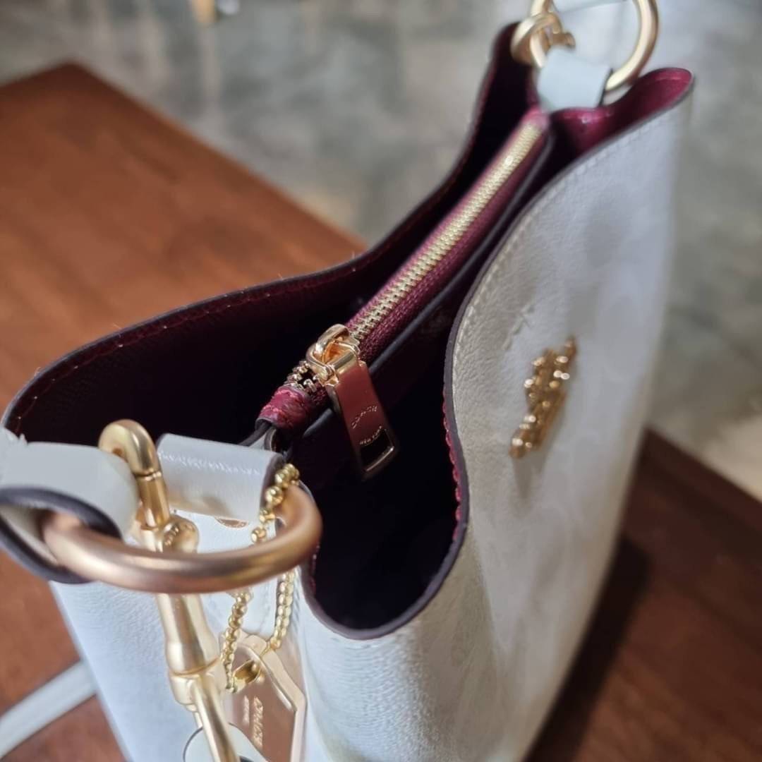 COACH 2312 SMALL TOWN BUCKET BAG IN SIGNATURE CANVAS รุ่นยอดนิยมใบเล็กมาครบสีแล้วจ้า กระเป๋าทรงบัคเก็ต สีผู้ดี๊ผู้ดี ตัวกระเป๋าดีไซน์คลาสสิคลายซี ดูโดดเด่น วัสดุหนังแคนวาสเคลือบลาย สวยคมทุกมุมจริงๆ!! เปิด-ปิดด้วยกระดุมแม่เหล็กทั้ง 2 ฝั่ง ภายในเป็นช่องโล่ง