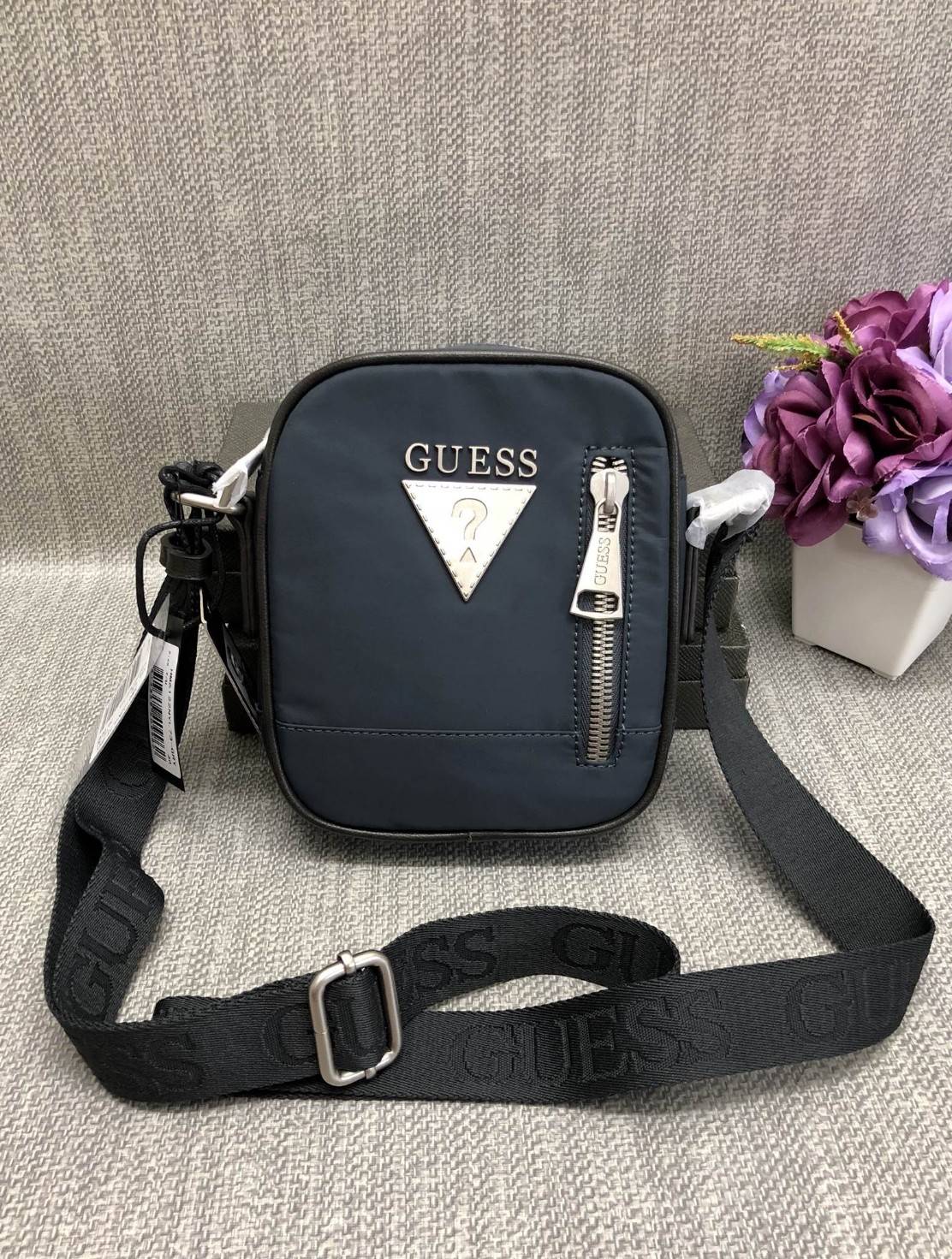 New GUESS SHOULDERBAG HM 6122 พร้อมส่งกระเป๋าสะพาย รุ่นนี้ใช้ได้ทั้งชาย/หญิง วัสดุไนล่อนอย่างดี คุณภาพสูง ด้านหน้าติดอะไหล่และโลโก้แบรนด์ มีช่องซิปใส่ของจุกจิก เปิดปิดกระเป๋าช่องหลักแบบซิป ด้านในโล่ง ลึก ใส่มือถือ กระเป๋าสตางค์ใบสั้นหรือสัมภาระอื่นๆได้พอป
