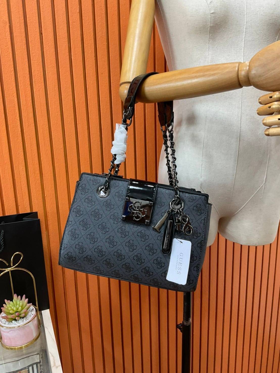 กระเป๋าสะพายไหล่ Guess Logo City Small Society Satchel กระเป๋าสะพายไหล่ ขนาดกำลังดี วัสดุ pu สวยอยู่ทรง มาพร้อมพวงกุญแจน่ารักๆ ถอดออกได้ ด้านหน้าประดับโลโก้แบรนด์ เปิดปิดด้วยซิป มี 2 ช่องหลักใช้งาน ภายในช่องซิปหน้าแยกเป็นสัดส่วนการใช้งาน ซิปช่อง 2 โล่งกว้