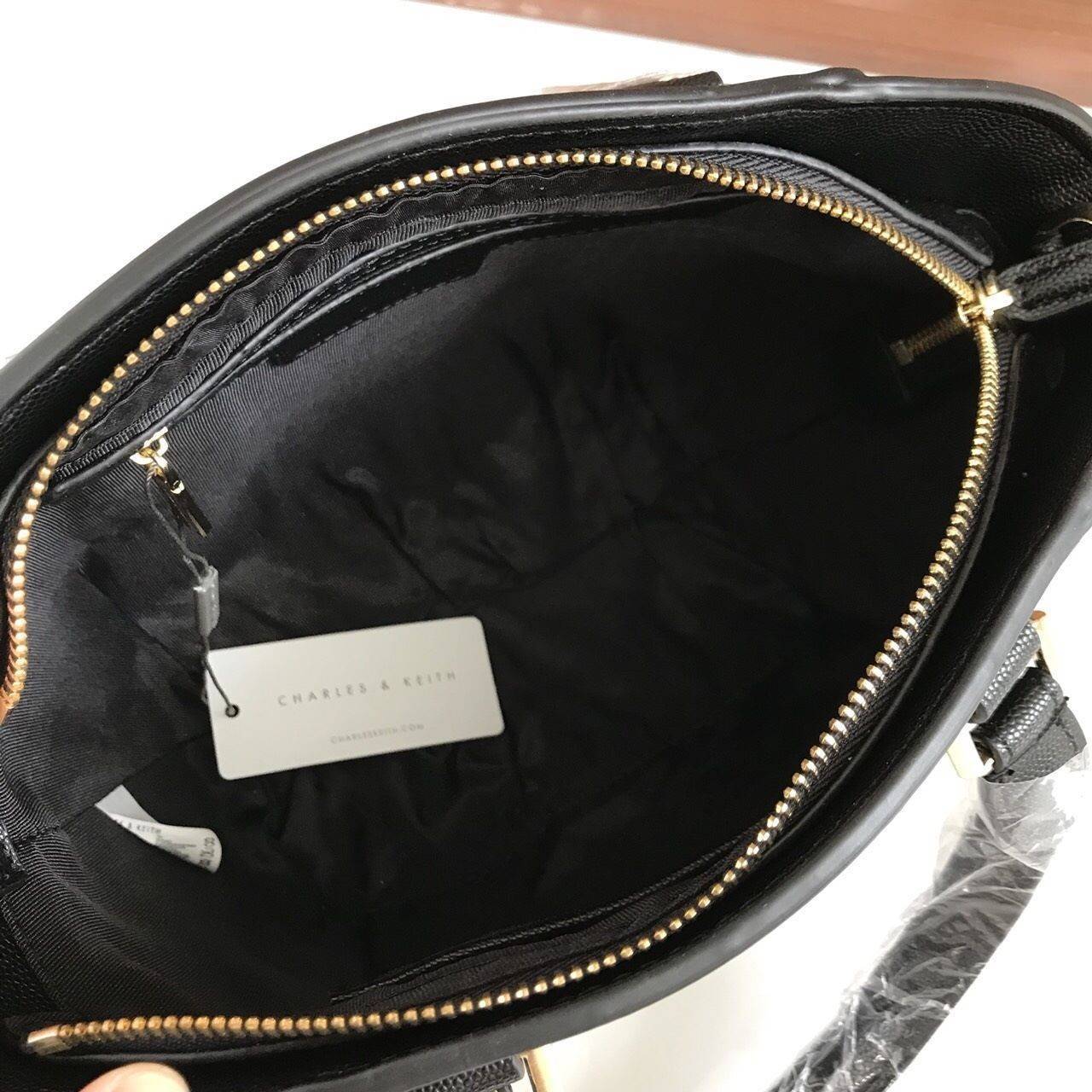 CHARLES & KEITH CITY BAG กระเป๋าถือหรือสะพาย ตั้งอยู่ทรงสวย มีโลหะรองฐาน เปิดปิดด้วยซิปเดียว ภายในมี 2 ช่องเล็กด้านหน้าประดับด้วยกระจกทรงกลม ใช้งานได้จริง ปั้มโลโก้แบรนด์ มาพร้อมสายสะพายยาว ปรับระดับและถอดสายได้ หูพับลงได้ น้ำหนักเบา ต้องมีไว้ครอบครองสักใ