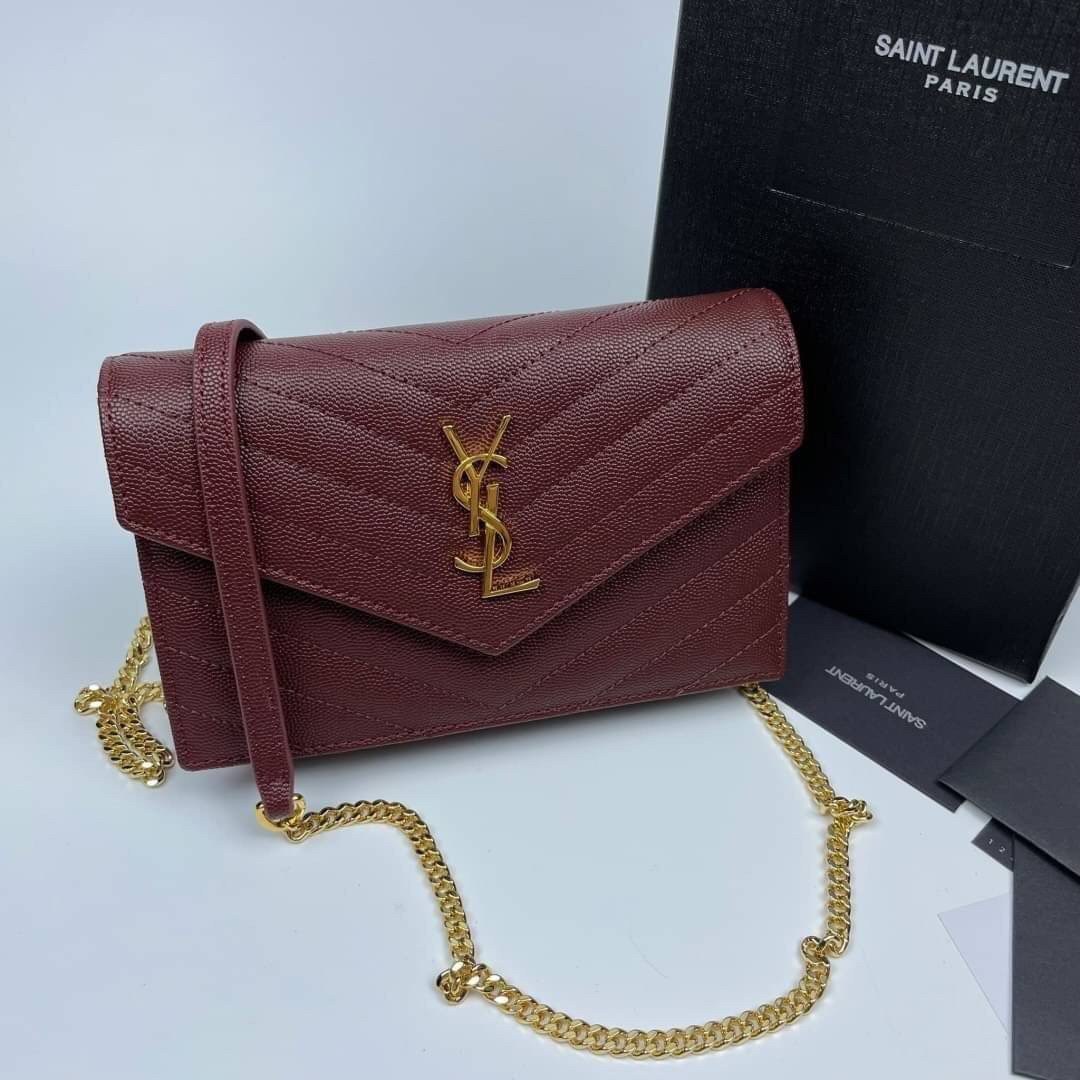 หนังแท้ YSL Yves Saint Laurent Envelope WOC 7.5” รุ่นฮอตปรอทแตก ทรงฐานตั้งได้ เป็นการดีไซน์กึ่งกระเป๋าสตางค์ ที่มาพร้อมสายสะพายยาว (เป็นสายโซ่ที่ต่อกับหนัง) สายถอดได้ (ปรับระดับไม่ได้) ถือเป็นคลัชก็สวยมากเลยค่ะ เป็นอีกหนึ่งรุ่นที่ให้ความรู้สึกเรียบแต่โก้ห