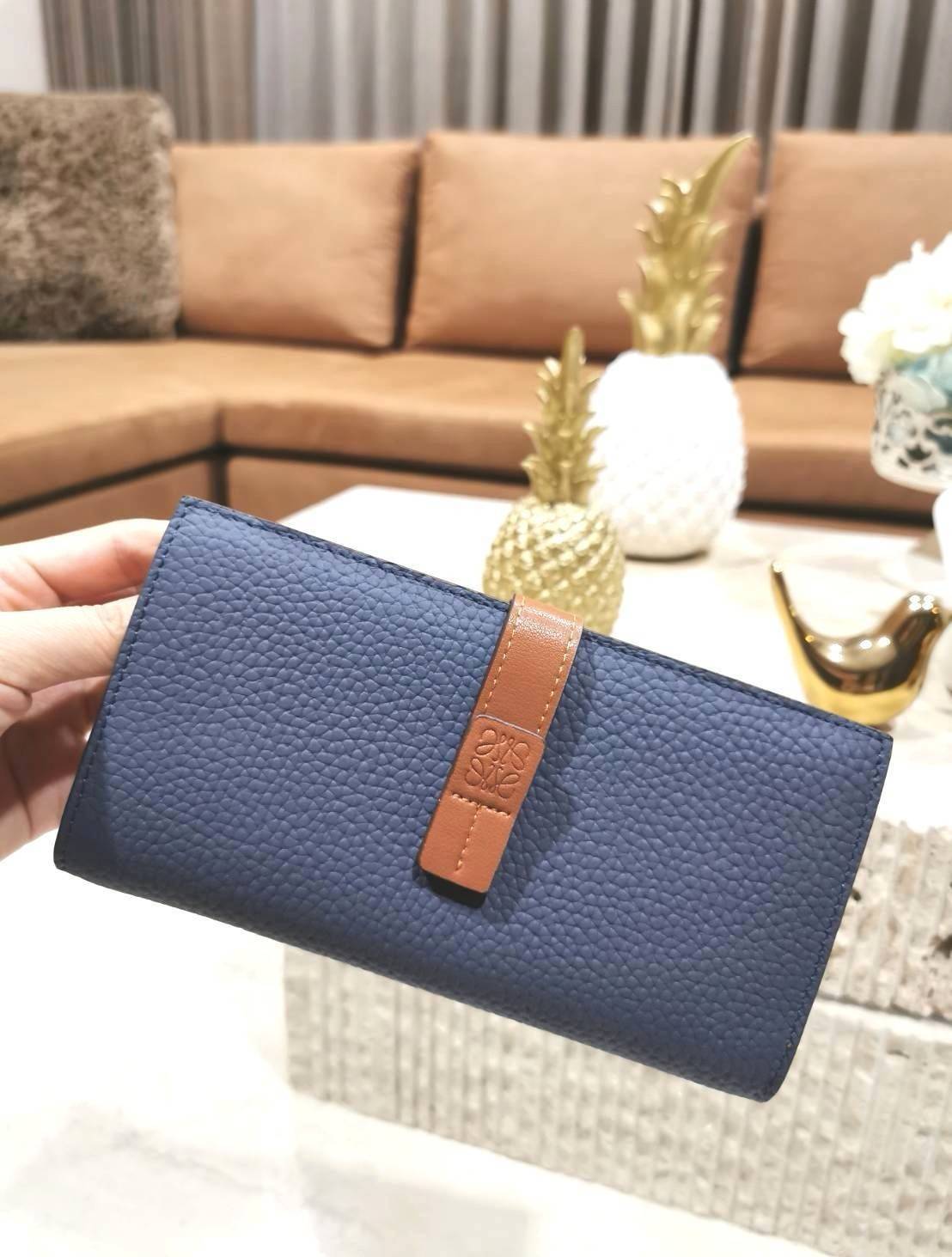LOEWE LONG WALLET BAG วัสดุหนังแท้เทคเจอร์สวยอยู่ทรงปั้มโลโก้แบรนด์ด้านหน้าเปิดปิดด้วยกระดุม ภายในมีช่องใส่ธนบัตรหลายช่อง ช่องหลักสามารถใส่มือถือได้ มีช่องซิปใส่เหรียญ ช่องใส่ธนบัตรใส่แบงก์พันได้ สวยน่าใช้ พร้อมส่งที่ไทยสุดคุ้มห้ามพลาด!