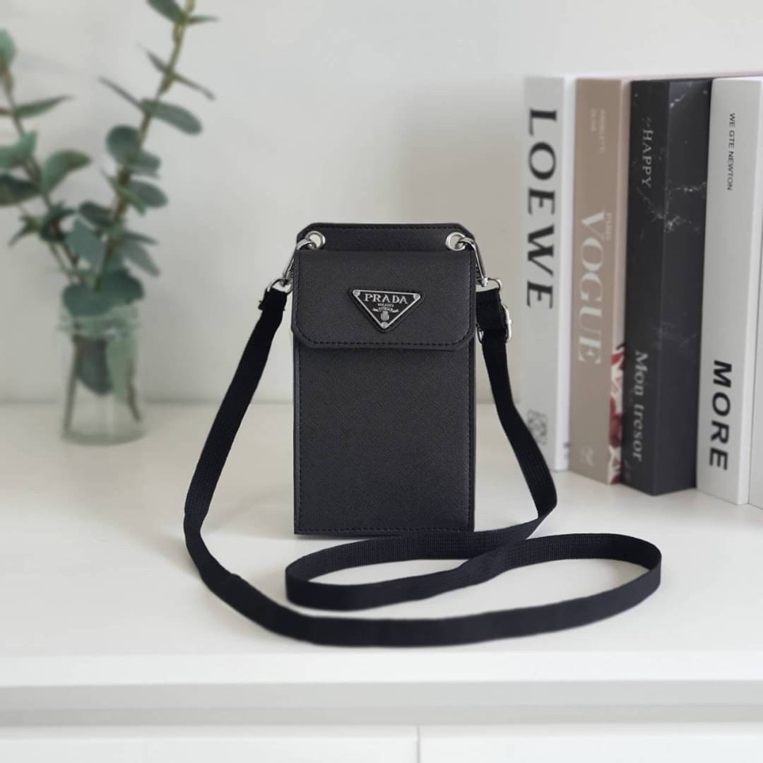 PRADA PHONE CASE ไอเท็มสุดคลาสสิคที่ทุกท่านควรมี! Prada Saffiano Leather Smartphone Case งานพรีเมี่ยมกิ้ฟท์จากเคาเตอร์ต่างประเทศ ของมีจำนวนจำกัด หนังลาย saffiano อยู่ทรงสวย ดีไซน์หรูหรา ดูดี ทรงCrossbody ด้านหน้ามีโลโก้แบรนด์ อะไหล่ทอง ด้านในเปิดปิดด้วยกร