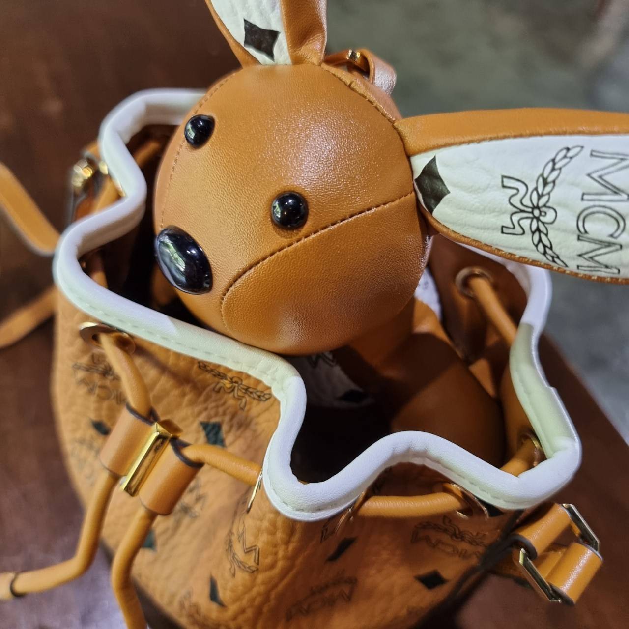 M.C.M ZOO RABBIT DRAWSTRING BAG IN VISETOS LEATHER MIX คอลเลคชั่นซูมาใหม่ ฮิตหนักมากที่เกาหลีและญี่ปุ่น ไอเท็มสุดคิ้วท์ น้องกระะต่ายโดดเด่น กระเป๋าสะพายทรง bucket ไซส์เล็กขนาดน่ารักน่าใช้ แฟชั่นสไตล์มากใบนี้ ดีไซน์น้องกระต่ายแอบในกระเป๋า และสามารถนำออกมาห