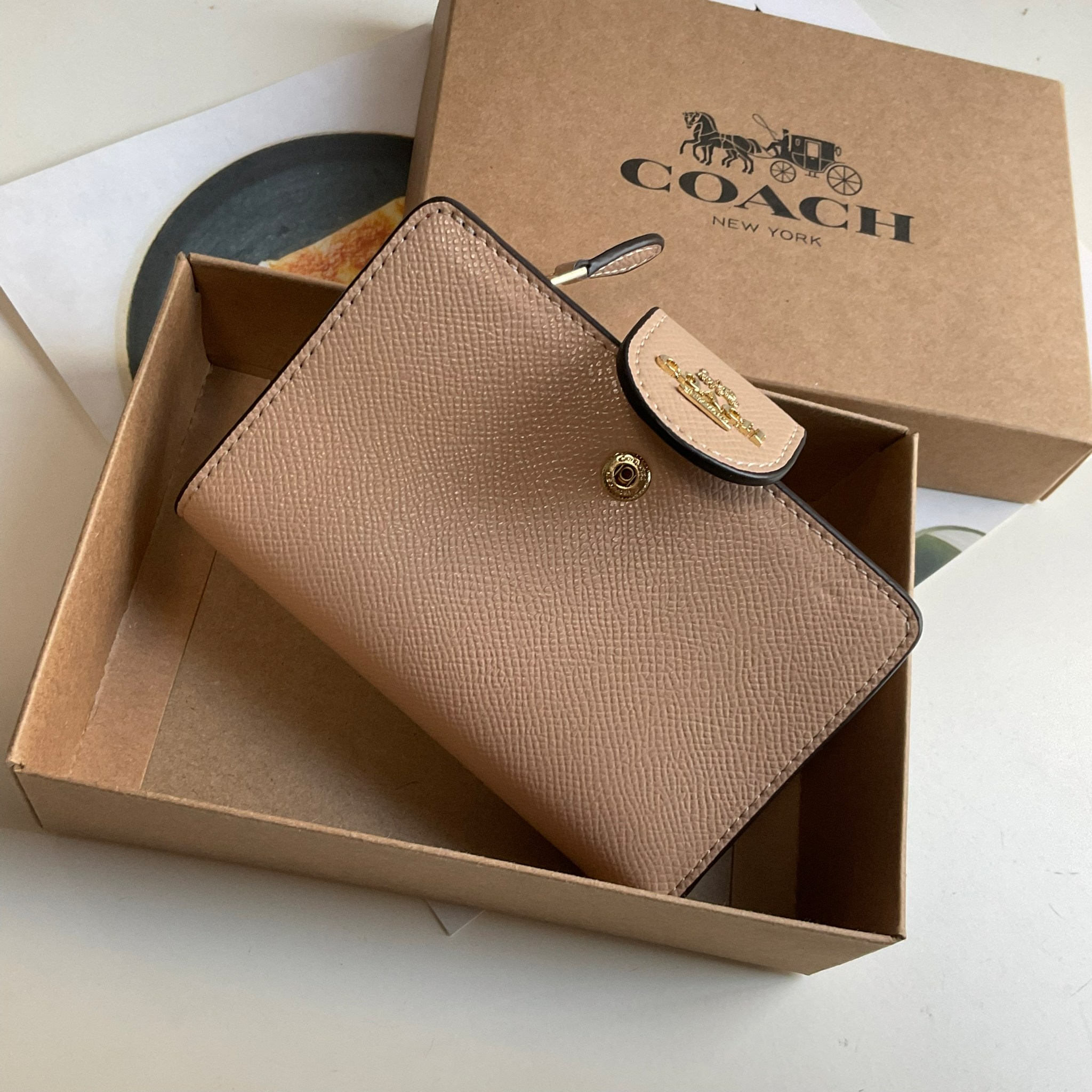 COACH SMALL WALLET IN SIGNATURE CANVAS กระเป๋าสตางค์ใบกลาง แบบพับสองตอน เปิดปิดด้วยกระดุมปั้มแบรนด์ ด้านในมีช่องใส่บัตรหลายช่อง พร้อมช่องใส่รูป และช่องใส่ธนบัตร ด้านหลังมีช่องซิปเหรียญอีกหนึ่งช่อง น้ำหนักเบา พกพาสะดวก อะไหล่ทองสุดหรู ห้ามพลาดค่ะ!