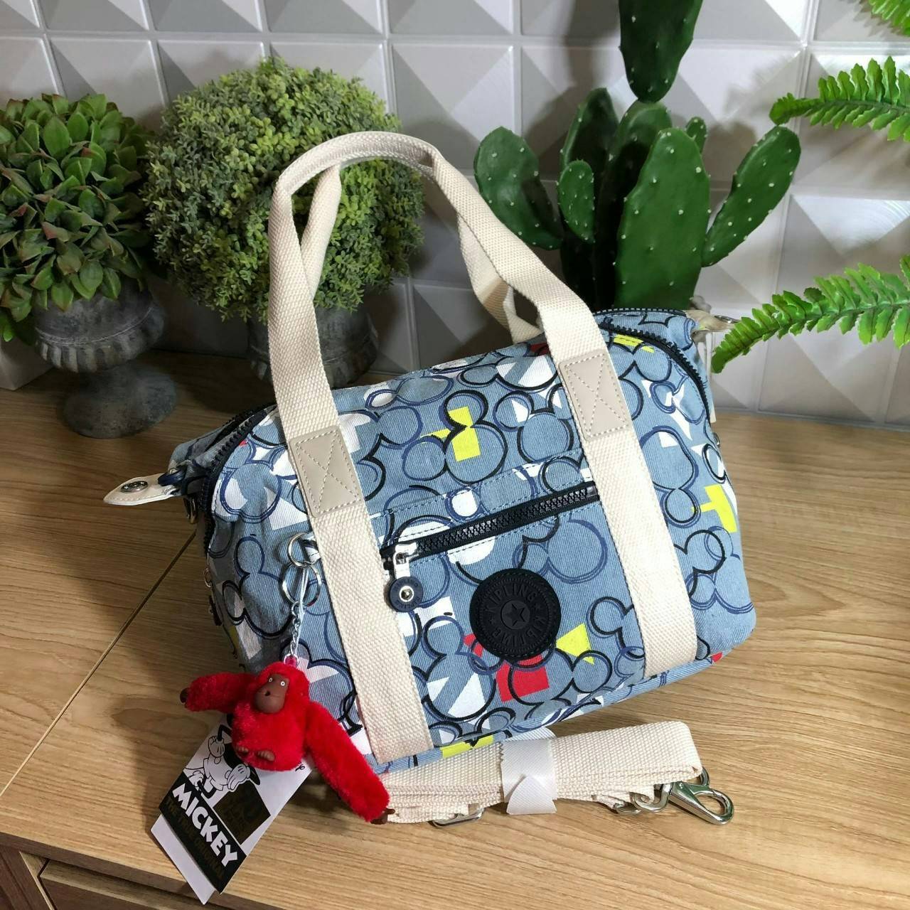 Kipling D ART MINI Collection Mickey กระเป๋าถืออเนกประสงค์ Art Mini จาก KIPLING ขนาดเล็กมีน้ำหนักเบา และช่องกระเป๋ากว้าง สะดวกในทุกการพกพาไปพร้อมคุณ มีมุมด้านข้างสามารถปรับได้ให้เข้ากับการใช้งานของคุณ โดยการรูดซิปลงเพื่อให้เป็นกระเป็นกระเป๋าสะพายดีไซน์เก๋