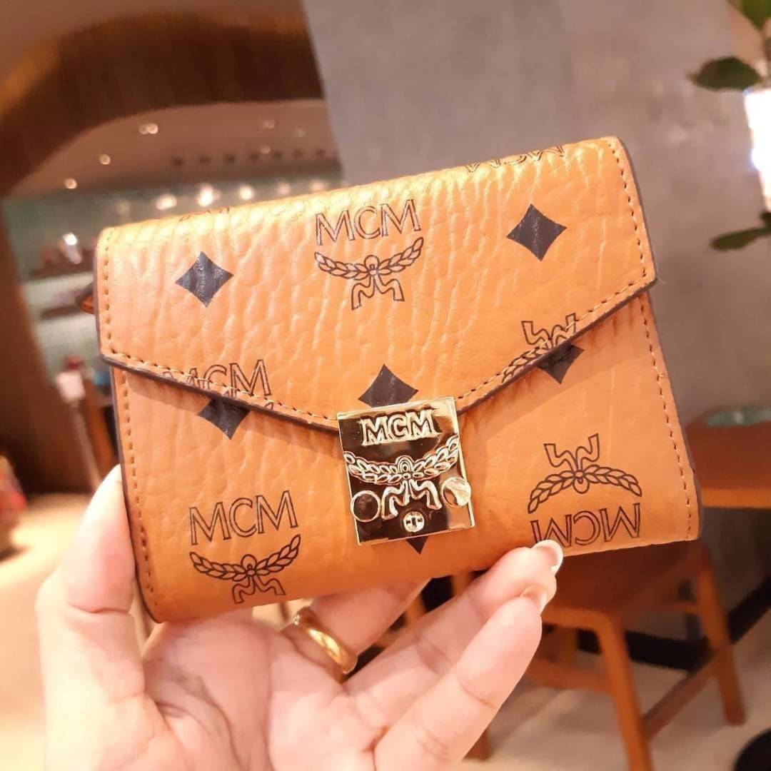 M.C.M PATRICIA THREE-FOLD WALLET IN VISETOS กระเป๋าสตางค์ใบเล็ก รุ่นฝาพับ unisex ใช้ได้ทั้งหนุ่มๆและสาวๆน้า ใช้งานง่าย ด้วยกระดุมโลโก้ พกพาง่าย วัสดุหนังแคนวาสคุณภาพดี ภายในเป็นหนังแท้ นิ่ม สวย ใส่บัตรได้เยอะ ใส่ธนบัตรได้ทุกชนิด ในช่องมีที่ใส่บัตรพิเศษภาย