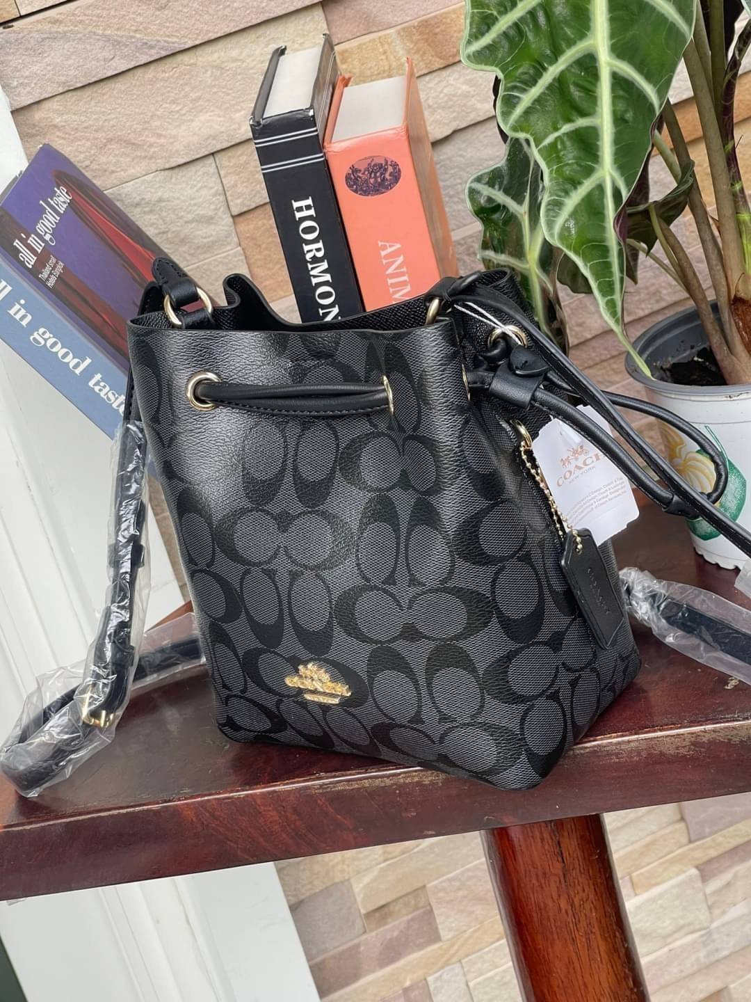 Coach Lena Crossbody Signature Bucket Bag กระเป๋าสะพายไหล่สุดคลาสสิกรุ่นนี้ เป็นรูปทรงถัง ที่สามารถจุของได้กำลังดี สำหรับสาวๆสายแฟชั่นที่ชอบรายละเอียดชิคๆ ดีไซน์เก๋ ด้วยรูปทรงของกระเป๋าที่ออกแบบมาให้ฐานเป็นรูปสี่เหลี่ยมทำให้กระเป๋ายังคงรูปทรงได้ง่าย มีสาย