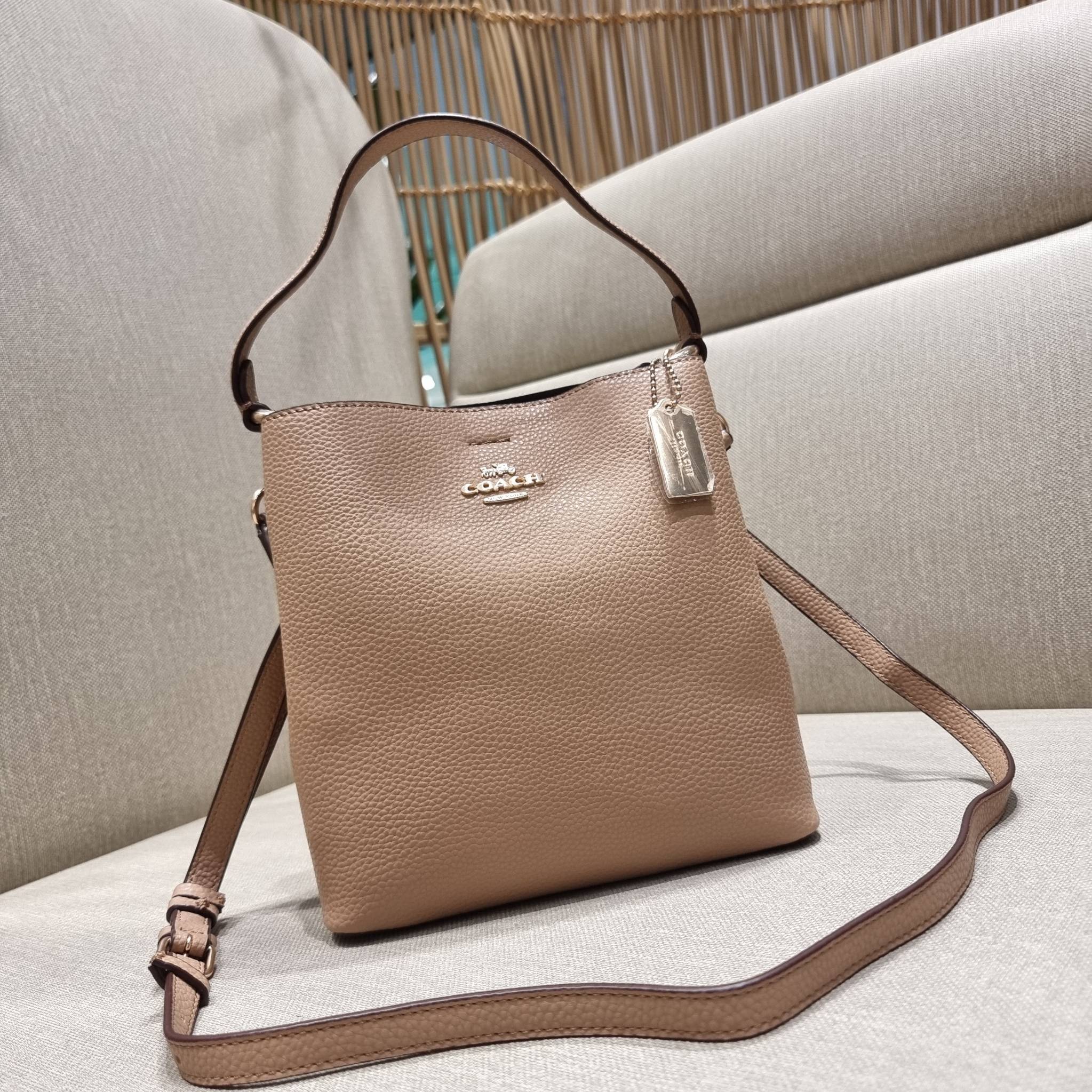 COACH 1011 SMALL TOWN BUCKET BAG รุ่นยอดนิยมใบเล็ก กระเป๋าทรงบัคเก็ต สีคลาสสิคเรียบหรู ตัดกับโลโก้สีทองดูโดดเด่น วัสดุหนัง pepble สวยคมทุกมุมจริงๆ!! เปิด-ปิดด้วยกระดุมแม่เหล็กทั้ง 2 ฝั่ง ภายในเป็นช่องโล่ง มาพร้อมสายสะพายปรับได้ตามตัว ขนาดใบนี้กำลังสวย สะพ