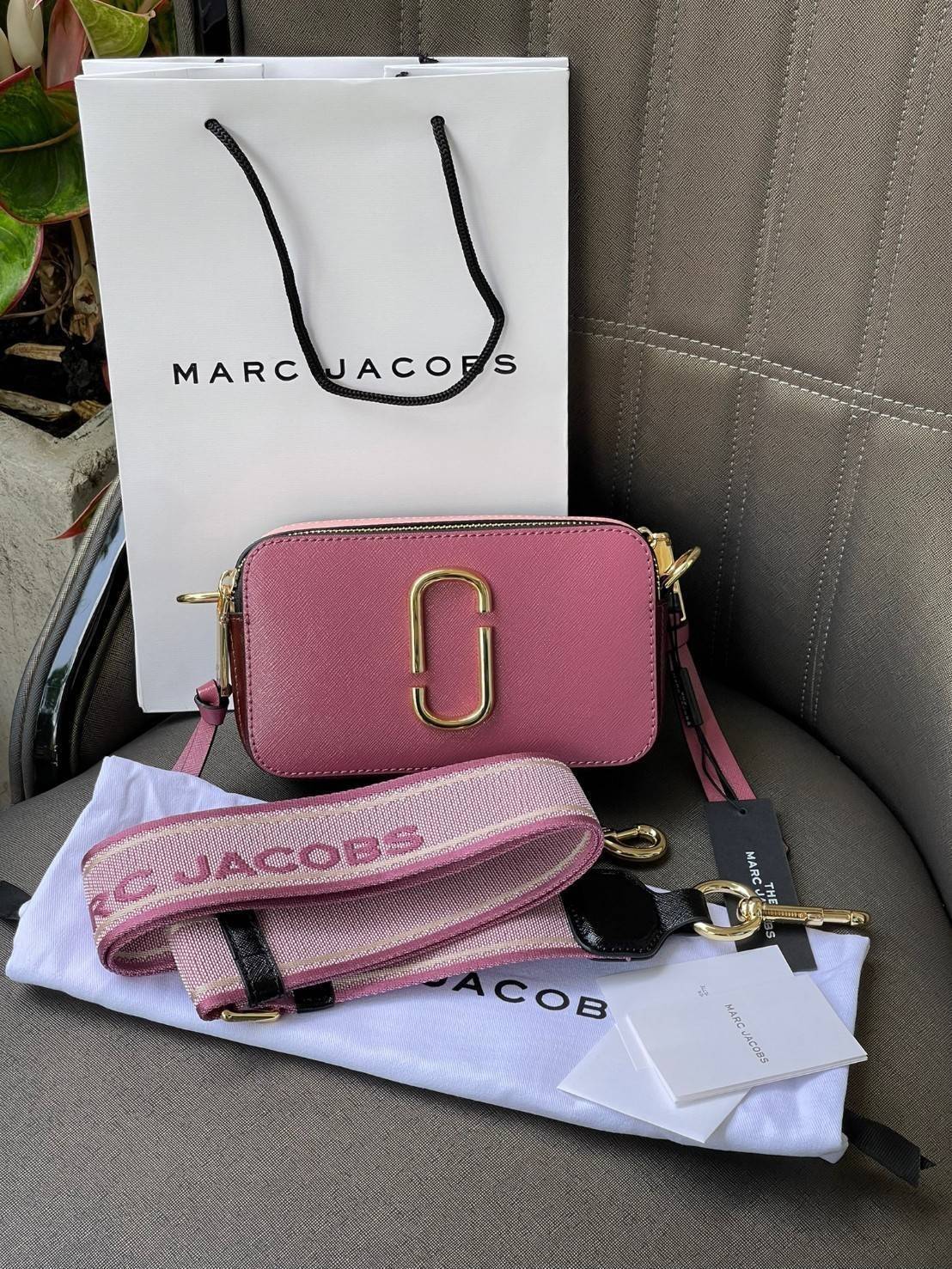 Marc Jacobs Snapshot Bag กระเป๋าแบรนด์ดังจากสัญชาติอเมริกัน นับได้ว่ารุ่นนี้เป็นรุ่นทรงฮิตเลยทีเดียว โดยด้านหน้ากระเป๋าจะเป็นโลโก้แบบโลหะที่เป็นสัญลักษณ์ของแบรนด์นี้ มาพร้อมสายสะพายที่จะสะพายยังไงก็ดูโดดเด่น เพราะขนาดใหญ่ที่สกรีนตัวอักษรโลโก้ ในรูปแบบต่าง