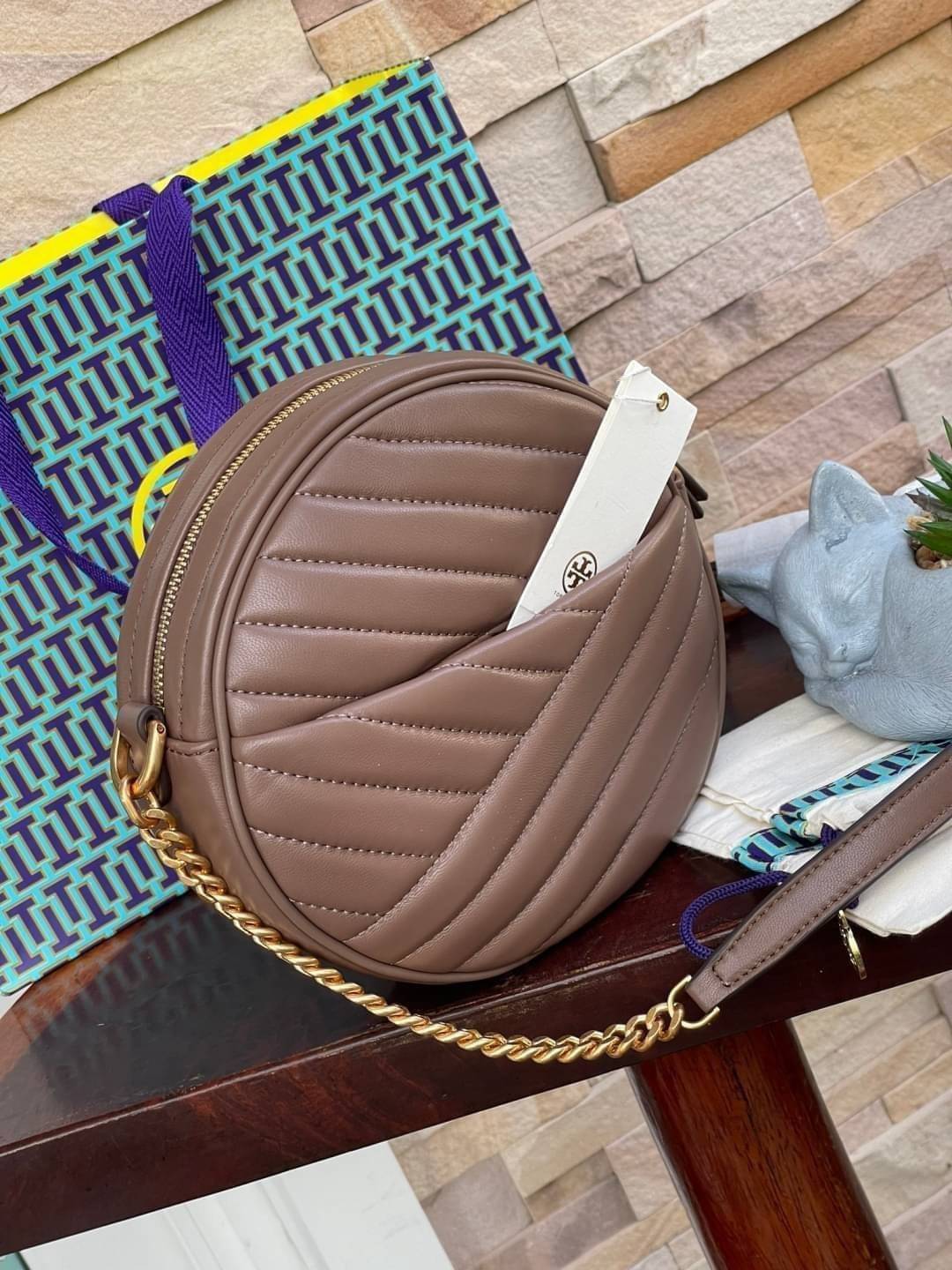 Tory burch Kira Cheron Circle Crossbody กระเป๋าสะพายคาดลำตัวรุ่นนี้โดดเด่นด้วยรูปทรงกลมสุดชิค ขนาดกะทัดรัด พร้อมด้วยหนังกระเป๋าที่ทำจากหนังแท้คุณภาพดี เพราะ Kira Chevron เป็นรุ่นที่ตอบโจทย์และครองใจสาว ๆ ได้อย่างแท้จริง เนื่องจากมีดีไซน์เรียบหรู โดยทางแบร