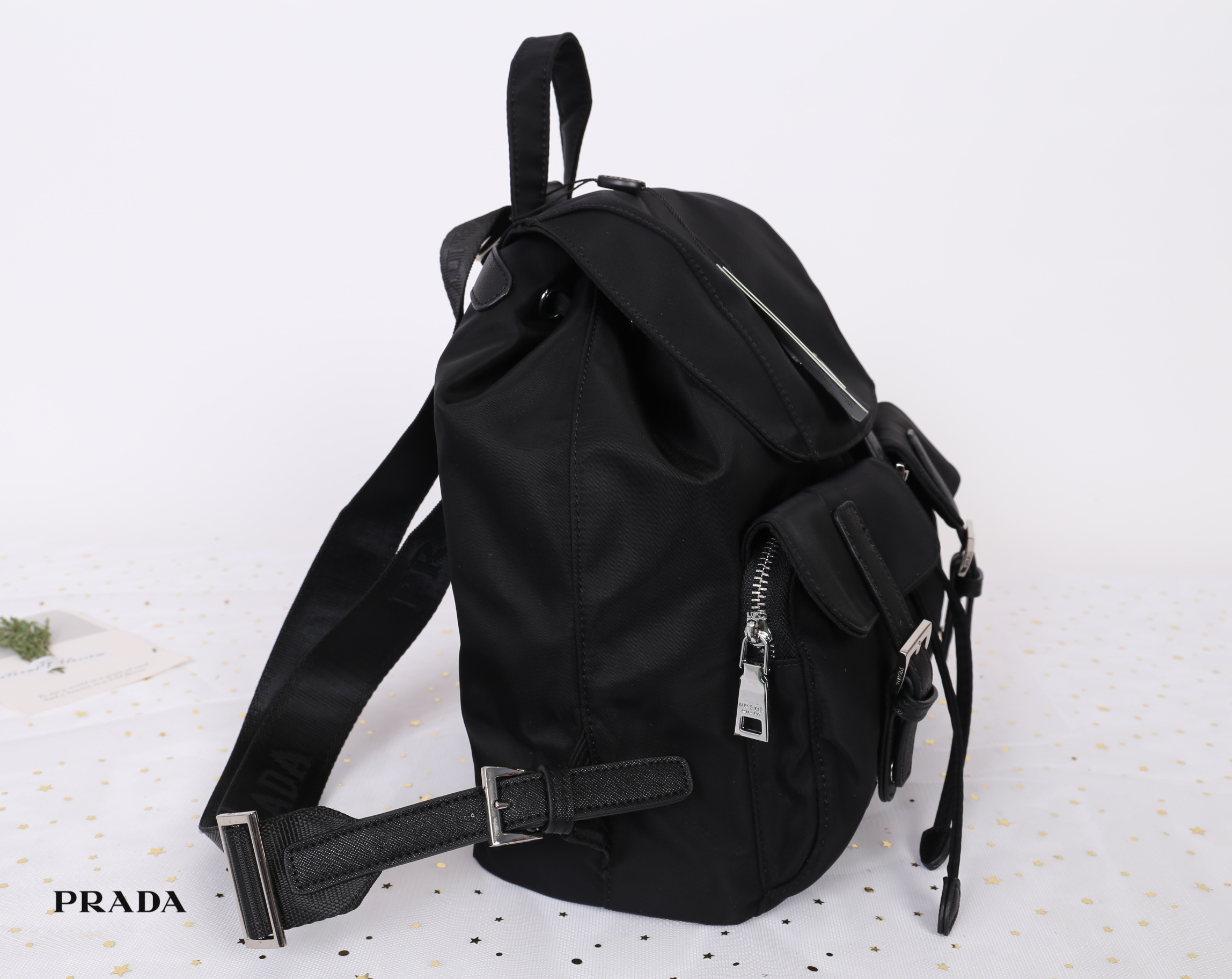 PRADA premium gift Nylon Backpack With Pocket วัสดุผ้าไนล่อนกันน้ำเนื้อหนาอย่างดี ใบนี้ ดีไซต์สวยเก๋ งานดีมากๆ อะไหล่แบรนด์ทุกจุด ใบนี้เก๋ตรงที่ เป็นเป้แบบหูรูด ทรงสวยน่ารัก แถมยังมีเปิดปิดด้วยกระดุมแม่เหล็กและแต่งด้วยเข็มขัดปรับได้ด้วย ด้านหน้ามีกระเป๋าอ