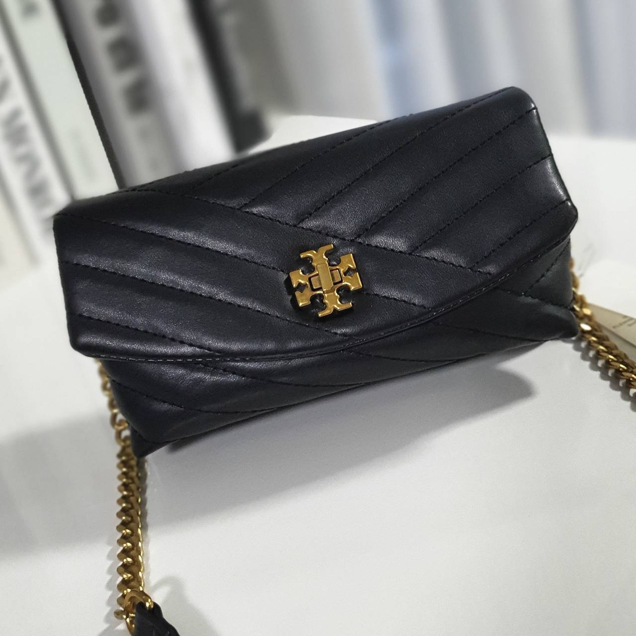 Tory Burch Kira Crossbody Bag กระเป๋าสะพายข้างทรงสวย ใบขนาดเล็กกำลังดี วัสดุหนังสังเคราะห์ นิ่มมือมากกก **อะไหล่ทองวินเทจ ประดับโลโก้แบรนด์เป็นตัวล็อคด้านหน้า ด้านในบุผ้าไนลอนปั้มแบรนด์ แบ่งช่องเป็นสัดส่วน พร้อมช่องซิปกลาง สามารถใส่กระเป๋าสตางค์ใบกลาง มือ