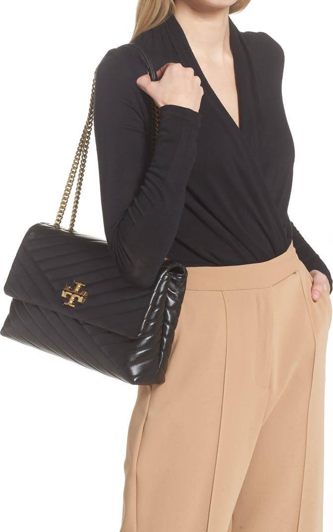 TORY BURCH KIRA CHEVRON CONVERTIBLE SHOULDER BAG กระเป๋าสะพายรุ่นยอดฮิต ไซส์ใหญ่จัดเต็มให้เน้นๆ ใช้ยังไงก็ดูหรู ดีไซน์เฉพาะตัว วัสดุหนังแกะ สัมผัสนิ่ม เปิด-ปิดด้วยกระดุมแม่เหล็ก ภายในเป็นช่องโล่ง แบ่งสัดส่วนไว้ดีมากๆ ใส่กระเป๋าสตางค์ มือถือ เครื่องสำอางค์