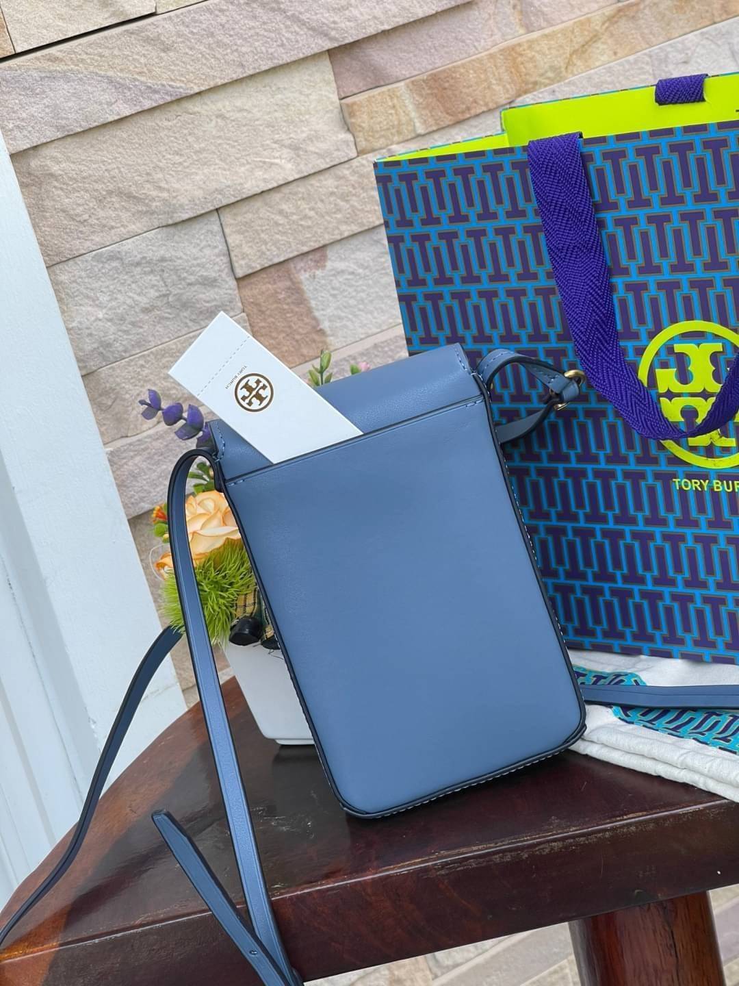 TORY BURCH MILLER METAL PHONE CROSSBODY อีกหนึ่งกระเป๋าใส่มือถือรุ่นฮิตที่เชื่อว่าหลาย ๆ คนต้องเคยเห็นผ่าน ๆ ตามาอย่างแน่นอน กับแบรนด์ Tory Burch ดีไซน์กระเป๋าทรงฝาพับแม่เหล็กใช้งานง่าย มาพร้อมดีเทล Logo สีเดียวกับเฉดสีของกระเป๋า แต่ยังมีความน่ารักด้วยทรง
