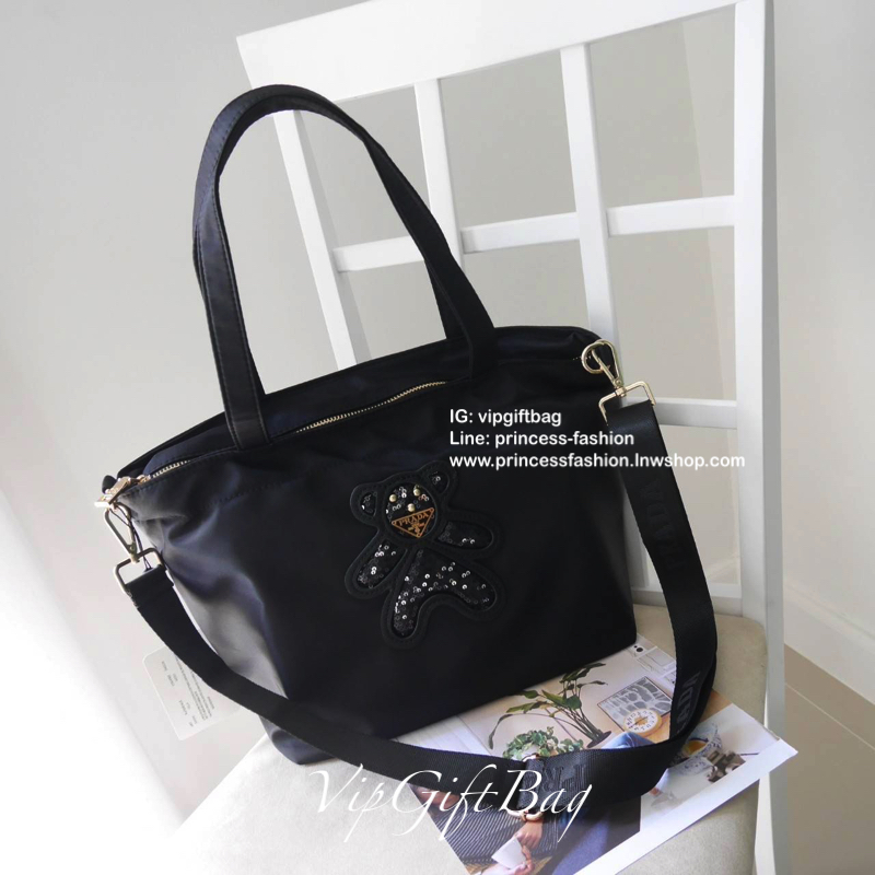 เอาใจคนชอบกระเป๋าไซส์กลาง *มาพร้อมสายยาว สำหรับกระเป๋าอเนกประสงค์ ทรง TOTE จากแบรนด์ PRADA เป็น กระเป๋าผ้าไนล่อน ตามแบบฉบับของแบรนด์เลย ใบนี้มีสายยาวให้ค่ะ เลิศมาก สะพายเป็น shoulder bag หรือ ถือได้คะ ด้านหน้าเป็นลายหมี ปั๊กกลิ้ตเตอร์ + logo brand ใช้แล้ว