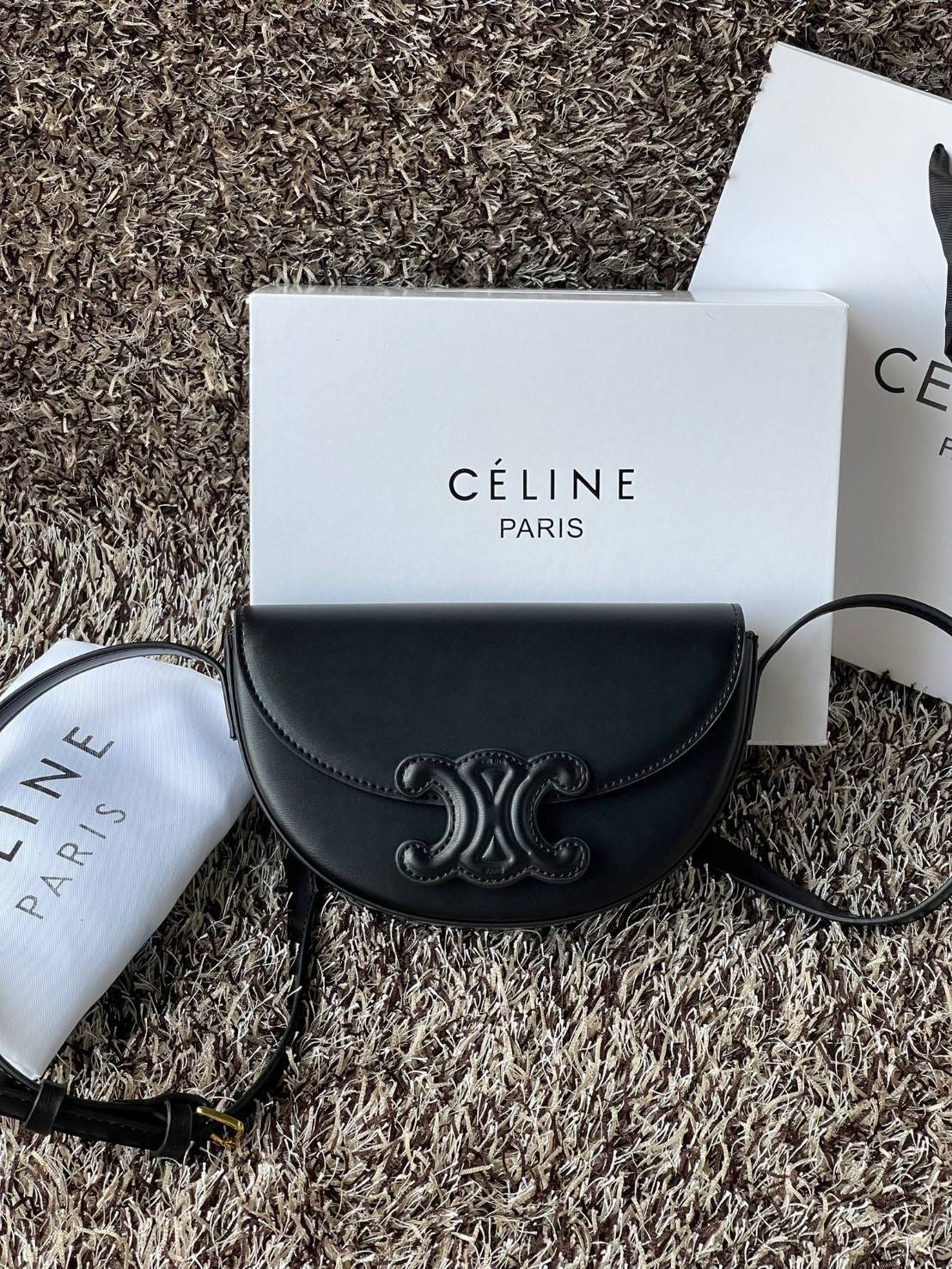 CELINE BESACE CUIR TRIOMPHE IN SMOOTH กระเป๋ารุ่นนี้นำเสนอในรูปทรงฮาล์ฟมูนที่ตอนนี้กำลังงมาแรง เปิดด้วยกระดุมแป๊กเพื่อเผยให้เห็นช่องภายในที่กว้างขวางและกระเป๋าด้านในแบบแบน คุณสมบัติที่โดดเด่นอีกอย่างของกระเป๋าอยู่ที่โลโก้ขนาดใหญ่ รูปทรงสะดุดตา สามารถสะพาย