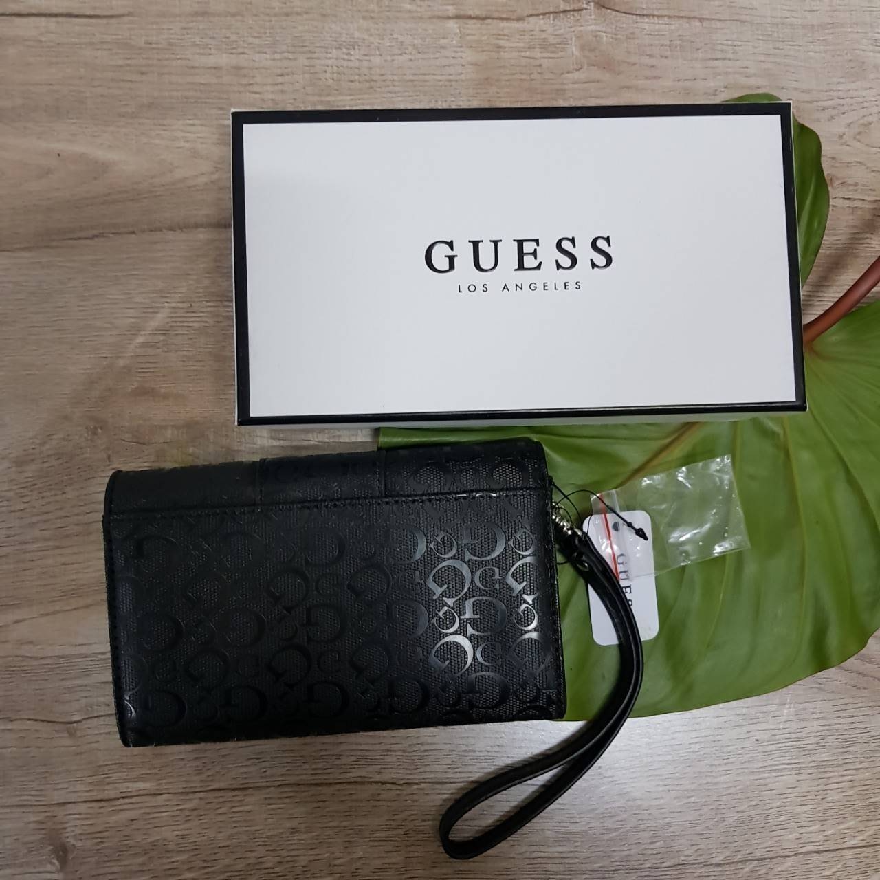 Guess leather wallet กระเป๋าสตางค์ใบกลาง มีสายคล้องมือสามารถถอดได้ ด้านหน้าแต่งโลโก้แบรนด์โลหะสีเงิน ภายในมีช่องใส่ธนบัตร,เหรียญ บัตรต่างๆ ปิดเปิดใช้งานสะดวก