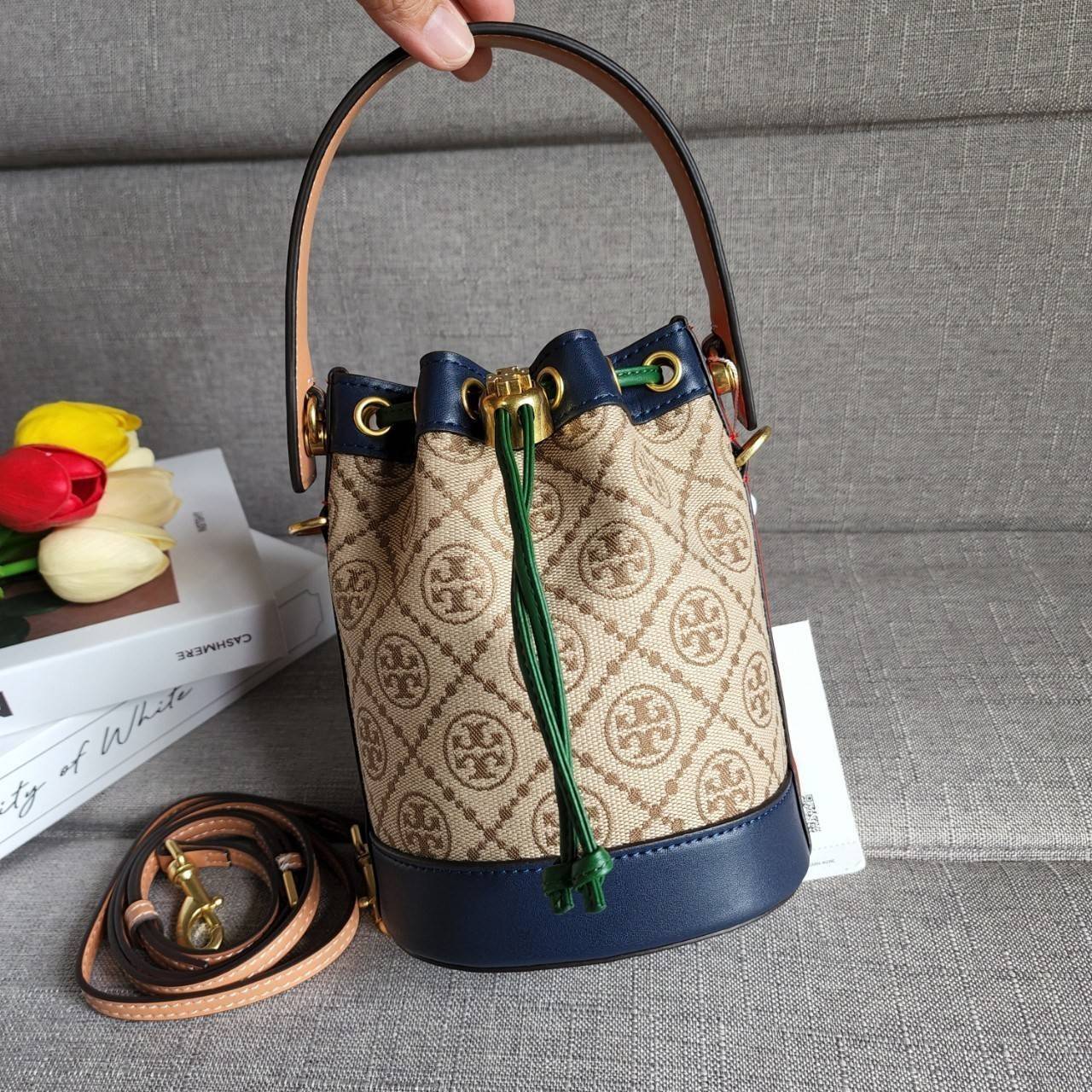 TORY BURCH T MONOGRAM COLORBlOCK JACQUARD MINI BUCKET BAG คอลเลคชั่นใหม่ล่าสุด ครอบครองก่อนใคร รุ่นบัคเก็ตทรงจีบ วัสดุ jacquard สลับหนังแท้ ตัดขอบข้างสีแดงทำให้ดูโดดเด่น หูจับหนังแท้ เปิด ปิด แบบหูรูด ภายในช่องโล่งกว้าง มาพร้อมสายสะพายข้างหนังแท้ ปรับระดั