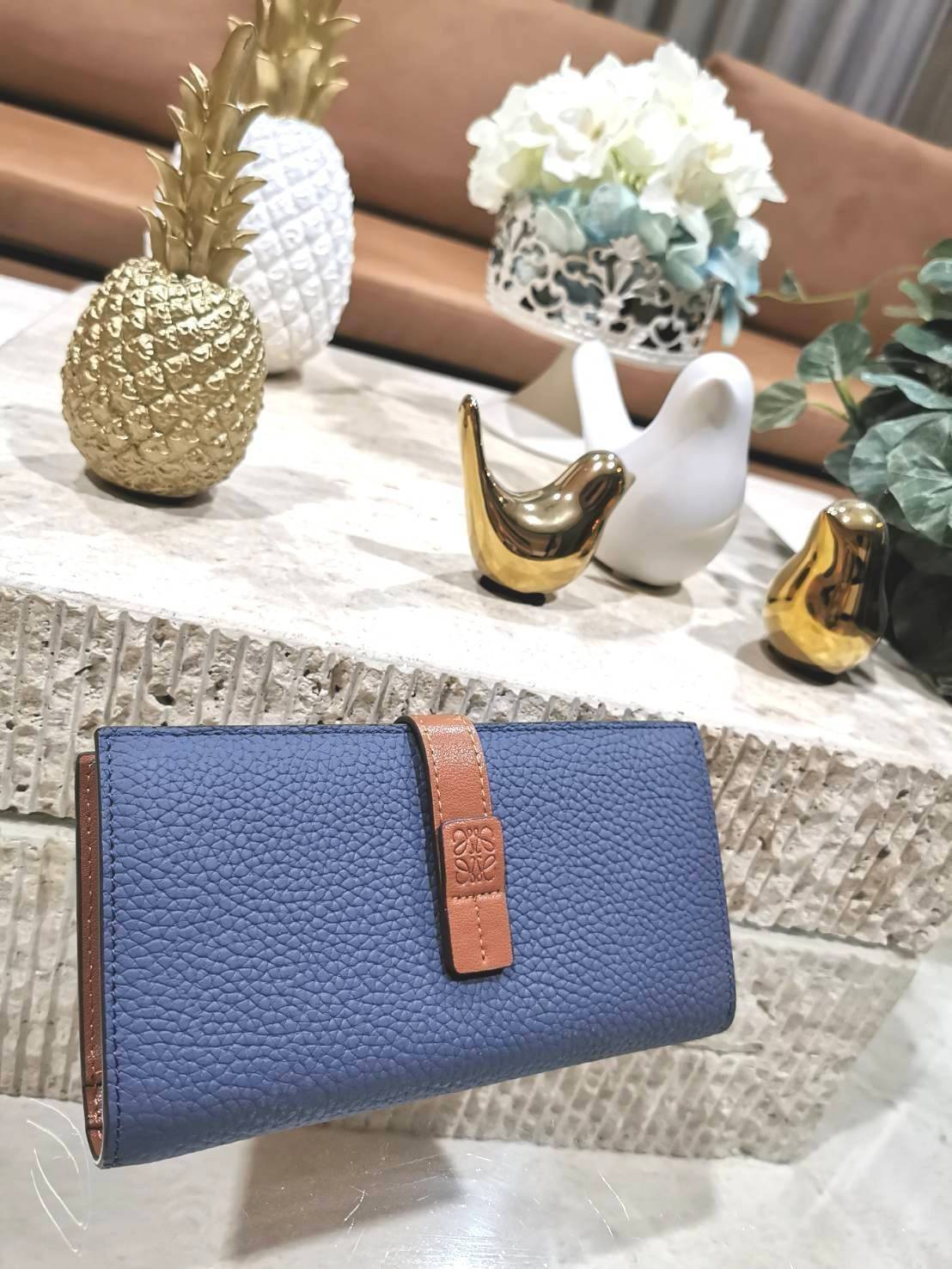 LOEWE LONG WALLET BAG วัสดุหนังแท้เทคเจอร์สวยอยู่ทรงปั้มโลโก้แบรนด์ด้านหน้าเปิดปิดด้วยกระดุม ภายในมีช่องใส่ธนบัตรหลายช่อง ช่องหลักสามารถใส่มือถือได้ มีช่องซิปใส่เหรียญ ช่องใส่ธนบัตรใส่แบงก์พันได้ สวยน่าใช้ พร้อมส่งที่ไทยสุดคุ้มห้ามพลาด!