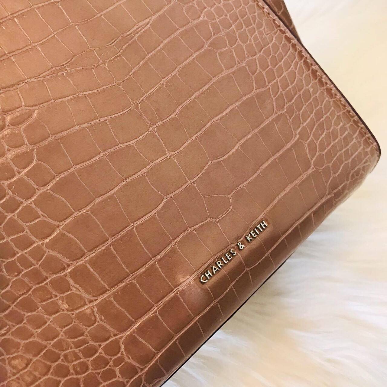 CHARLES & KEITH CROC-EFFECT TRAPEZE BAG กระเป๋าสะพายรุ่นใหม่ล่าสุด วัสดุหนังเรียบเงาสวย นิ่ม น้ำหนักเบา อะไหล่เงิน เปิดปิดกระเป๋าแบบกดล็อก ด้านในโล่งกว้างมีช่องซิปสำหรับใส่ของ ใส่กระเป๋าสตางค์ใบยาว Iphone+ได้ทุกรุ่น มาพร้อมสายสะพายยาวถอด-ปรับได้ฟรีไซร์ จน