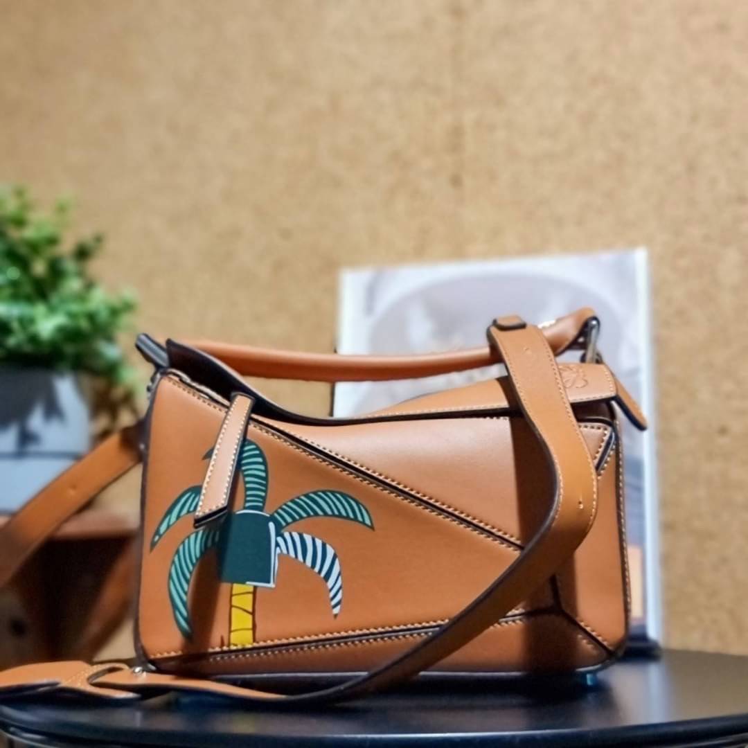 VIP 】LOEWE LA PALME PUZZLE BAG IN CLASSIC CALFSKIN คอลเลคชั่นใหม่!! กระเป๋าสะพายข้างทรงกล่อง สไตล์พัซเซิล ให้ฟีลลิ่งเหมือนตัวต่อ ดูดีได้ทุกที่แค่มีใบนี้ รอบนี้ดีไซน์พริ้นท์ลายต้นปาล์มเก๋ๆ ซัมเมอร์ยังต้องมา วัสดุหนังวัวฟอกสี เปิดใช้งานด้วยซิป ที่ภายในโล่งพ