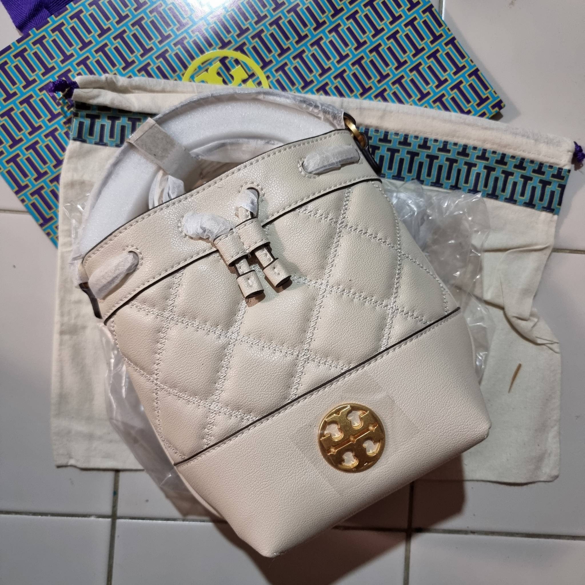 TORY BURCH WILLA MINI BUCKET BAG NEW ARRIVAL สุดปัง กระเป๋าสะพายทรงบัคเก็ต สวยผู้ดี โดดเด่นด้วยโลโก้สีทองดูหรู อัพลุคผู้ดี๊ผู้ดี วัสดุหนังแท้ ดีไซน์บุนวม เส้นคมดีเทลหรู เปิด-ปิดหนังรูดปากกระเป๋า มีหูหิ้วในตัว คล้องแขนเก๋ๆ ภายในเป็นช่องโล่ง มีช่องย่อย ใส่ข