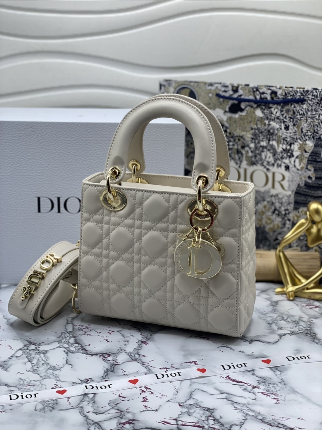 หนังแท้ DIOR LADY BAG 20cm ความสง่างามอีกหนึ่งรุ่นของ Dior รูปทรงสีเหลียม ขนาดกระทัดรัด ตั้งอยู่ทรง ฐานกระเป๋าแข็งแรง มีหมุดรองฐาน ดีไซน์ที่มีเอกลักษณ์เฉพาะตัว ด้านหน้าตกแต่งด้วยตัวอักษร D.I.R ห้อยเป็นพวงกุญแจ จะถือด้วยมือหรือสะพายไหล่ก็ดูดีมากๆ ค่ะ