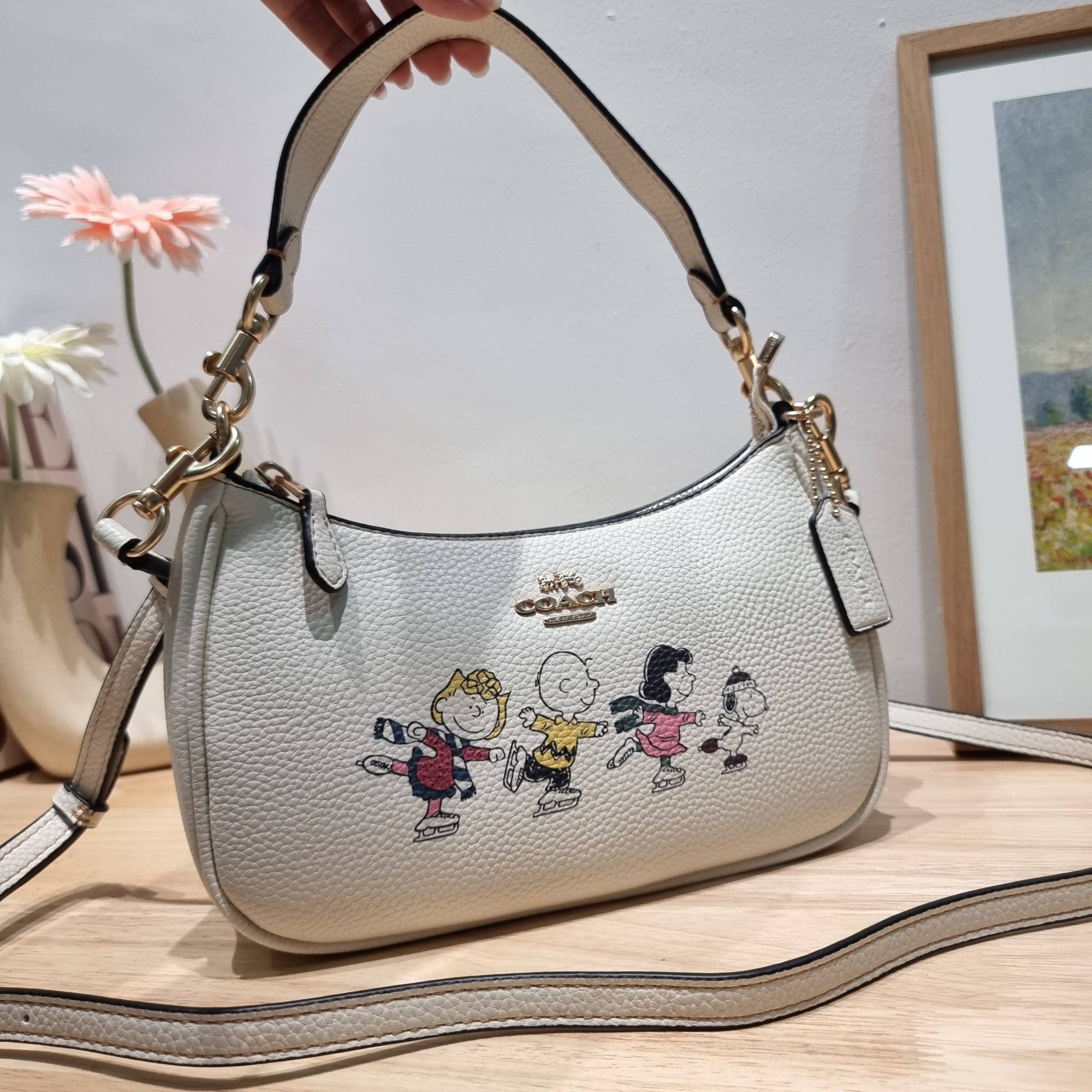 Coach X Peanuts Teri Shoulder Bag With Snoopy And Friends Motif CE861 คอลเลคชั่นสุดคิ้วท์ ไม่ให้ช้อปยังไงไหว!! กับกระเป๋าสะพายไหล่กึ่งทรงพอช พร้อมเสิร์ฟความสวยถึงบ้านไปเลยก่อนใคร แบบไม่ต้องพรีฯ ด้วยดีไซน์ลวดลายกาน์ตูนยอดฮิต มาพร้อมสายสะพาย 2 เส้น