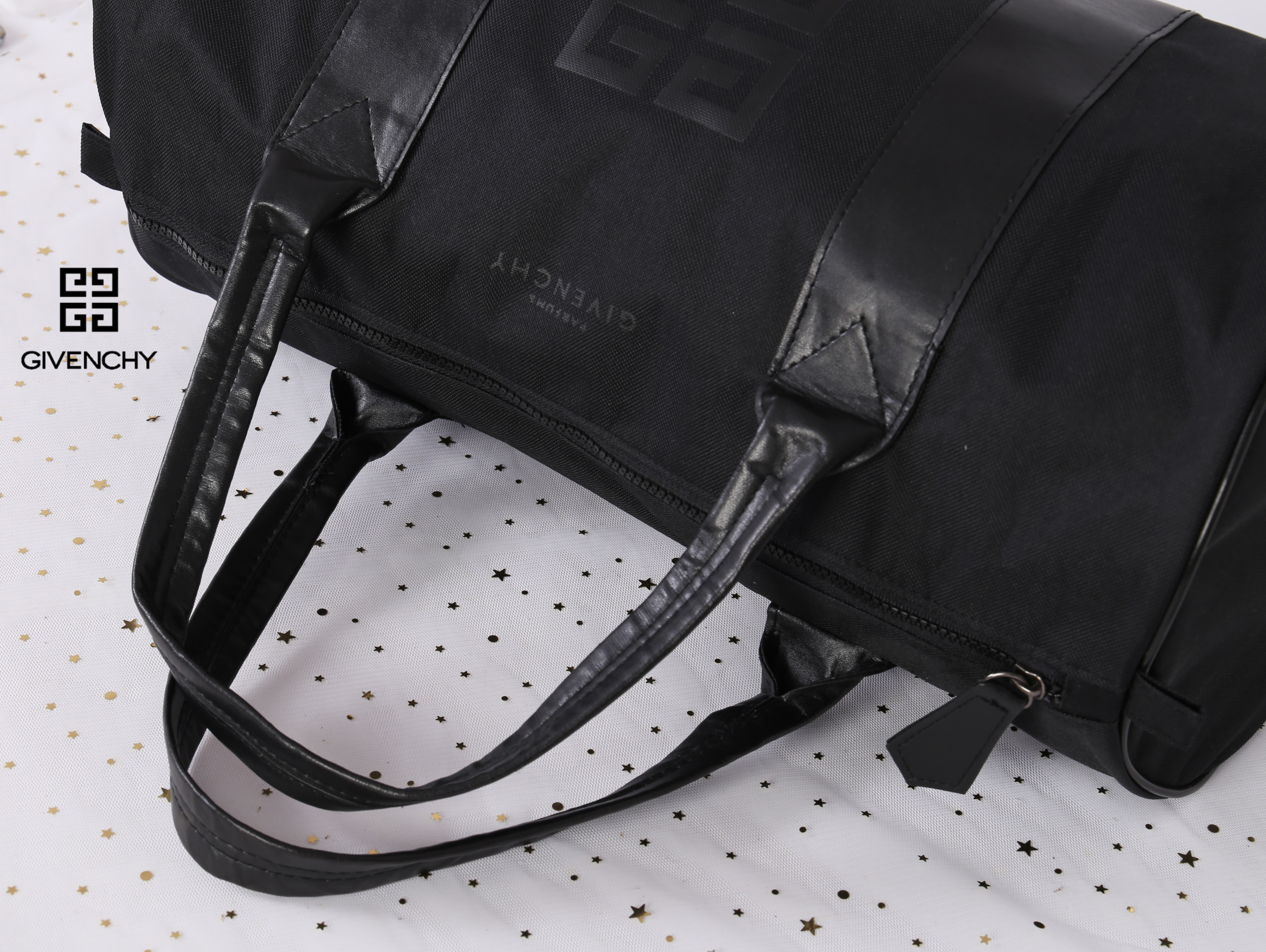 Givenchy Black Oxford Fabric Travel Bag สินค้าเป็นของใหม่ จากเค้าเตอร์เครื่องสำอาง/น้ำหอมของแบรนด์ กระเป๋าใบใหญ่สีดำ ทำจากผ้า Oxford สามารถกันน้ำได้ระดับนึง ด้านในบุด้วยผ้าซับสีดำอีกชั้น รุ่นนี้เป็นทรงกระบอก ตัวสายสะพายไหล่ทำจากหนัง แข็งแรงและทนทาน ใช้เป็